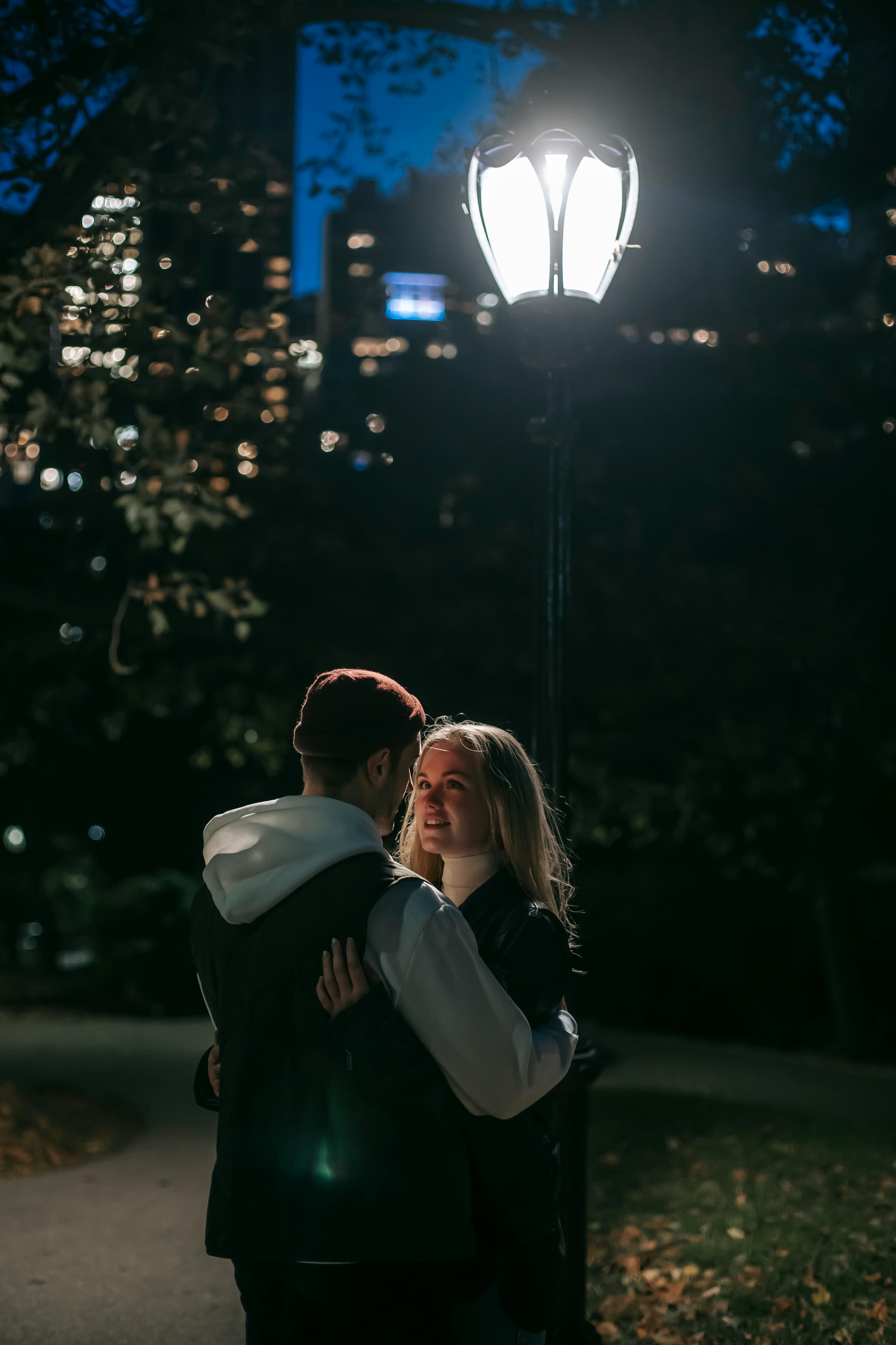 Un couple qui s'enlace dans un parc la nuit | Source : Pexels