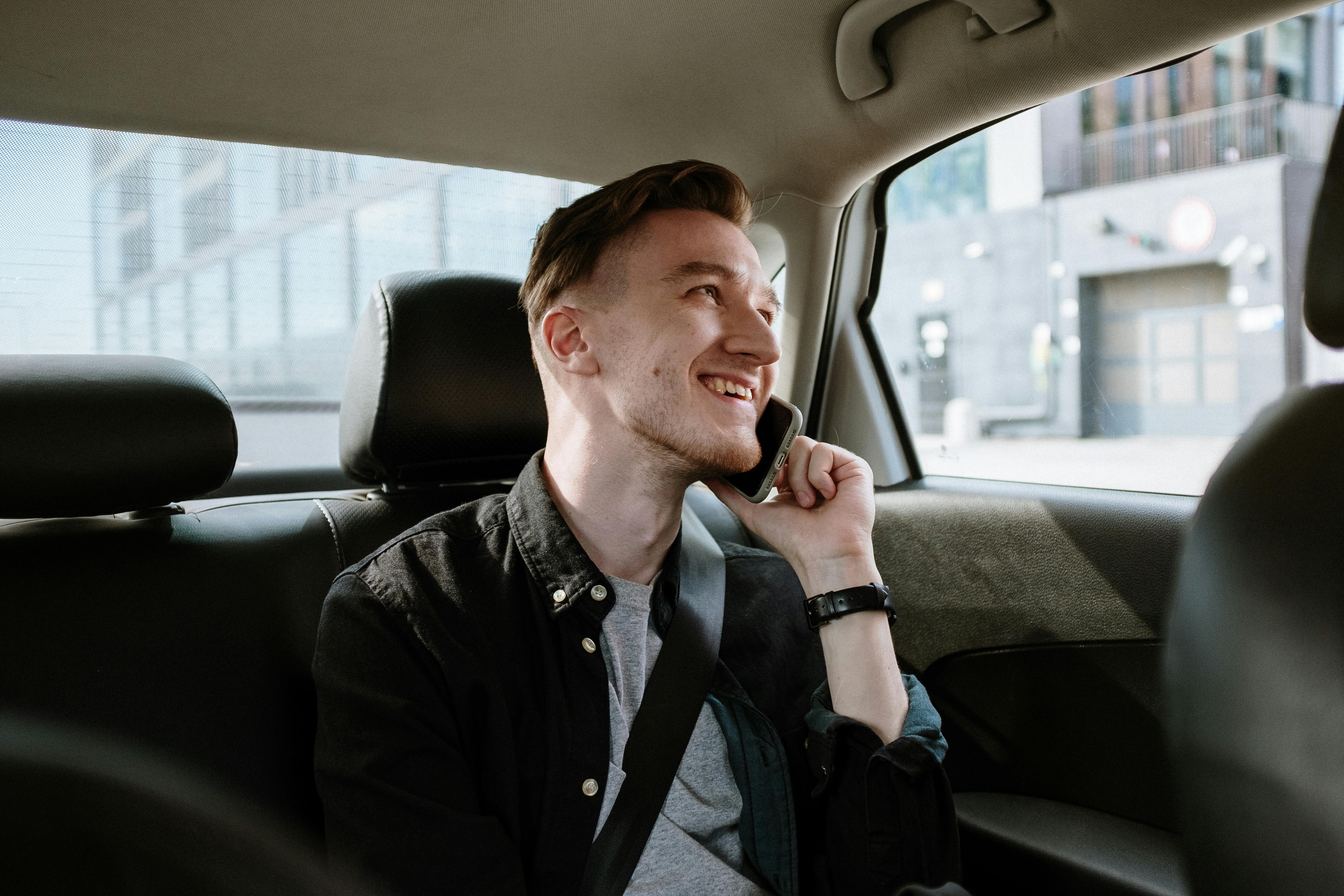 Un homme heureux qui parle au téléphone alors qu'il se trouve dans une voiture | Source : Pexels