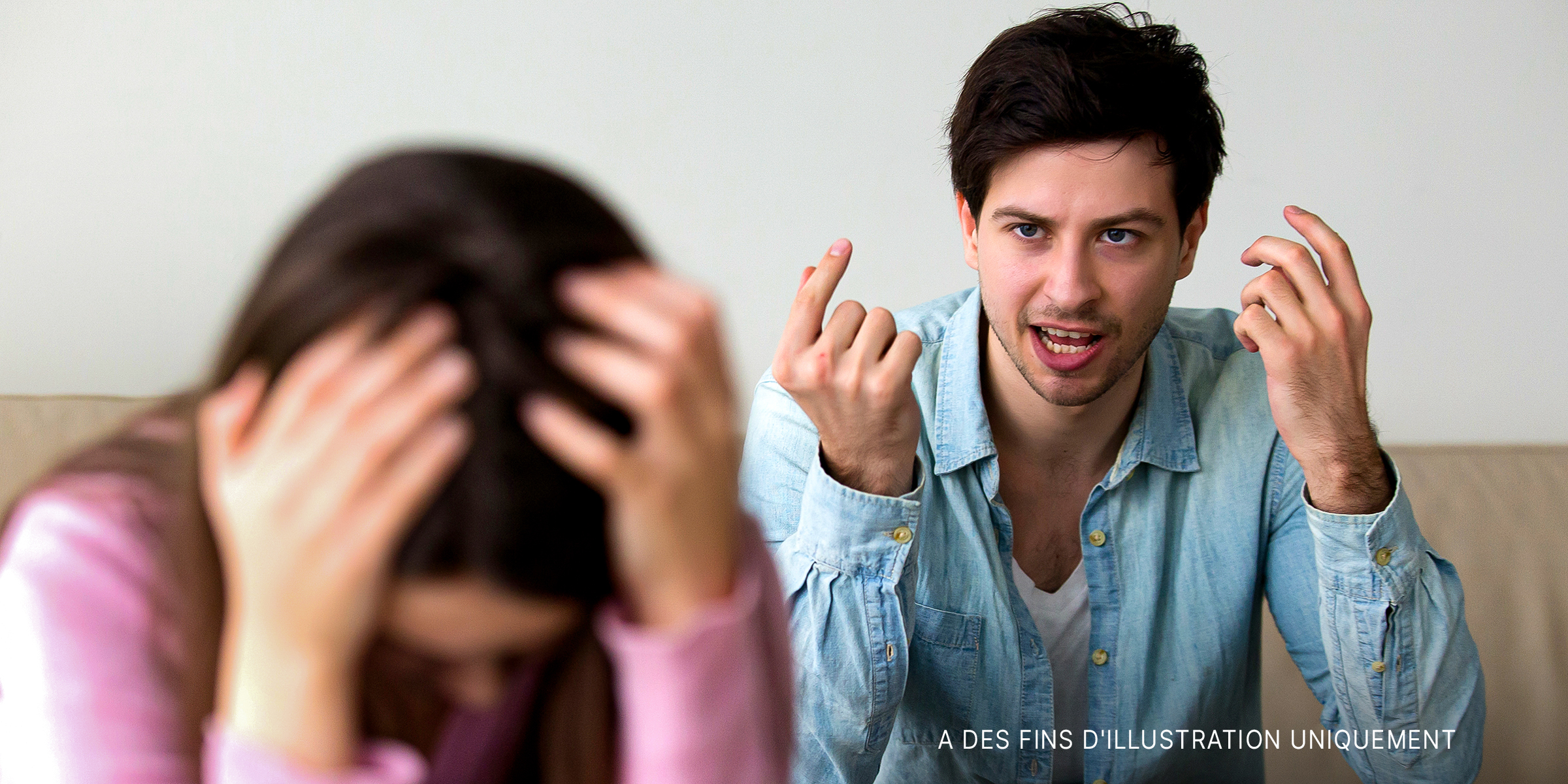 Un homme qui crie sur une femme alors qu'elle enfouit sa tête dans ses mains | Source : Shutterstock