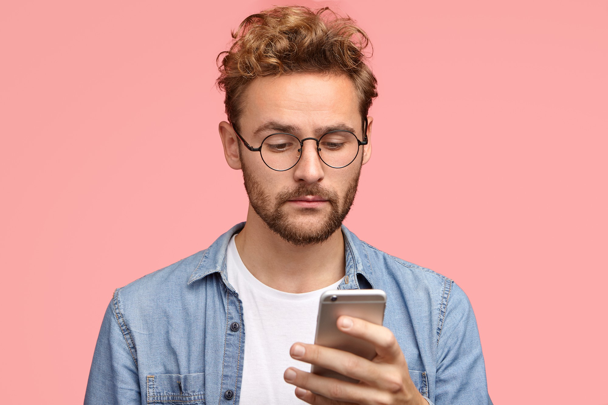 Un homme à l'air malheureux qui regarde son téléphone | Source : Freepik