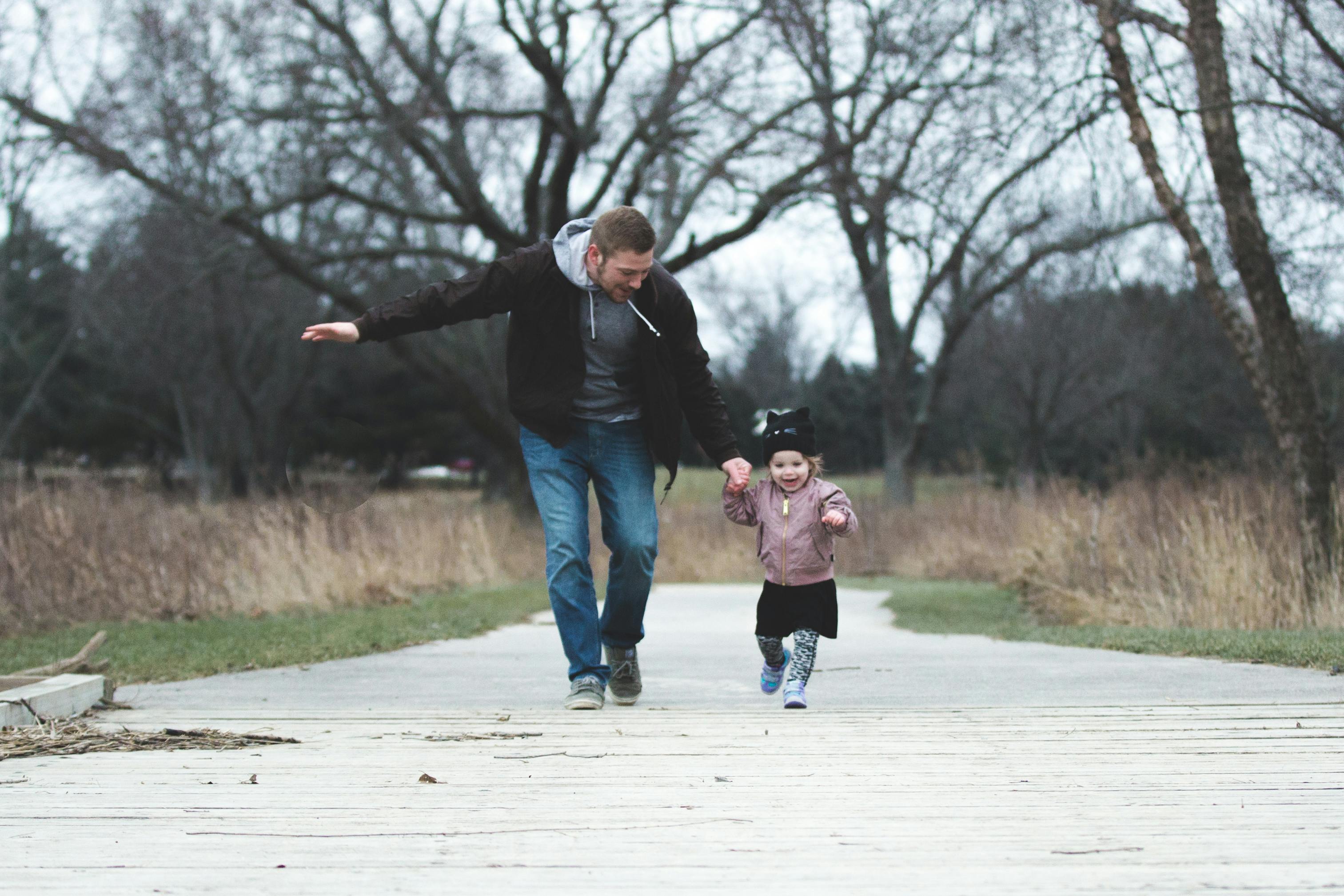 Un homme court avec sa petite fille | Source : Pexels