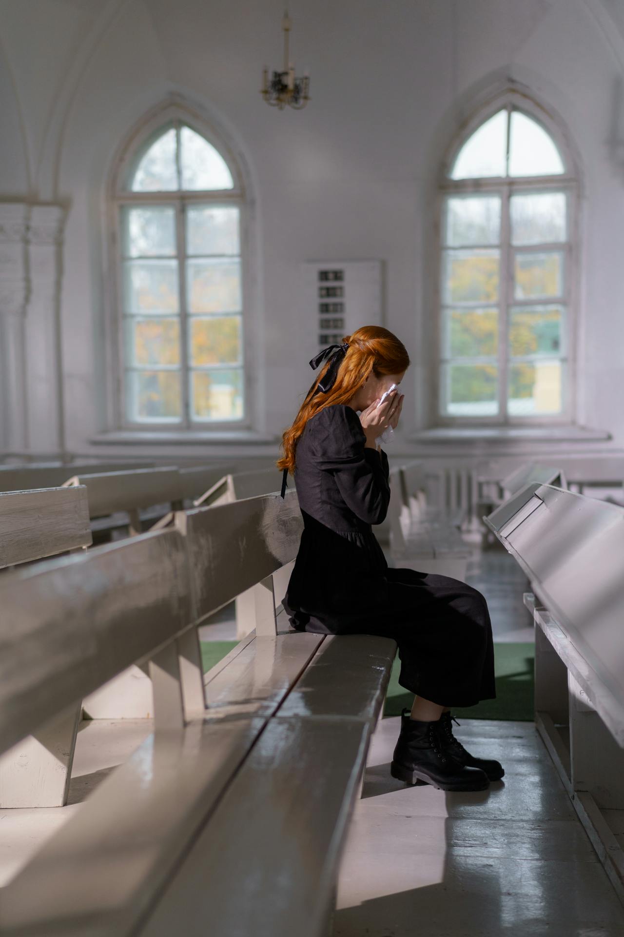 Une femme solitaire et émotive assise dans l'église et qui pleure | Source : Pexels