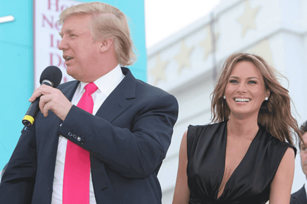 Donald Trump s'exprimant au micro avec Melania Trump à ses côtés pour sa fête d'anniversaire et le dévoilement de la nouvelle machine à sous Bally au Trump Taj Mahal, le 13 juin 2005, Atlantic City | Source : Getty Images 