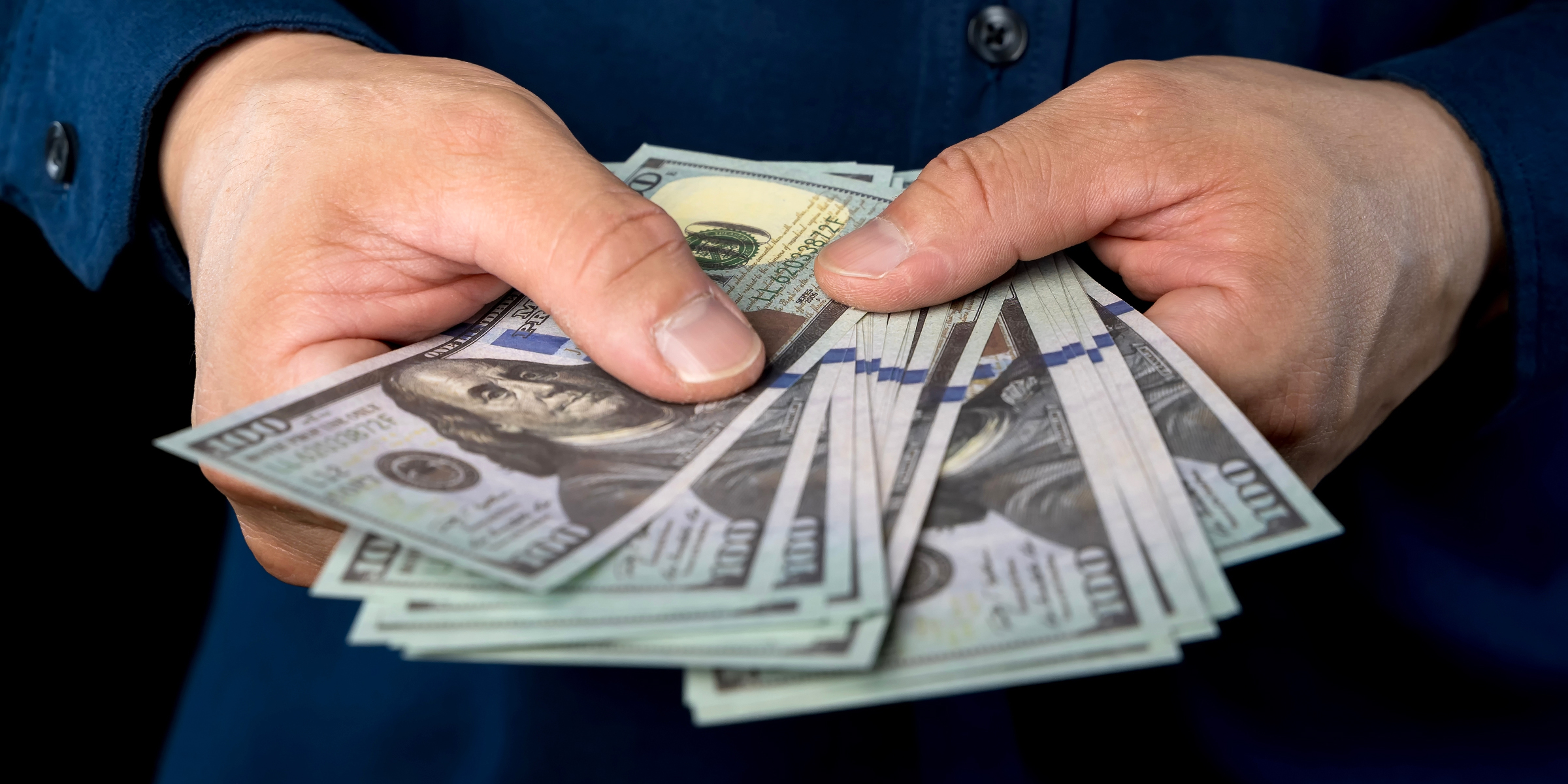 Une personne tenant des billets de banque | Source : Shutterstock