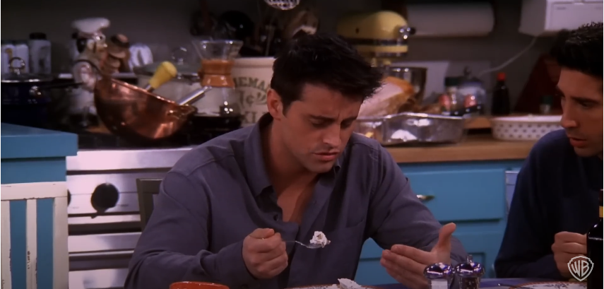 Matt LeBlanc dans le rôle de Joey sur le plateau de "Friends" en train de prendre un dessert | Source : YouTube/@warnerbrostv