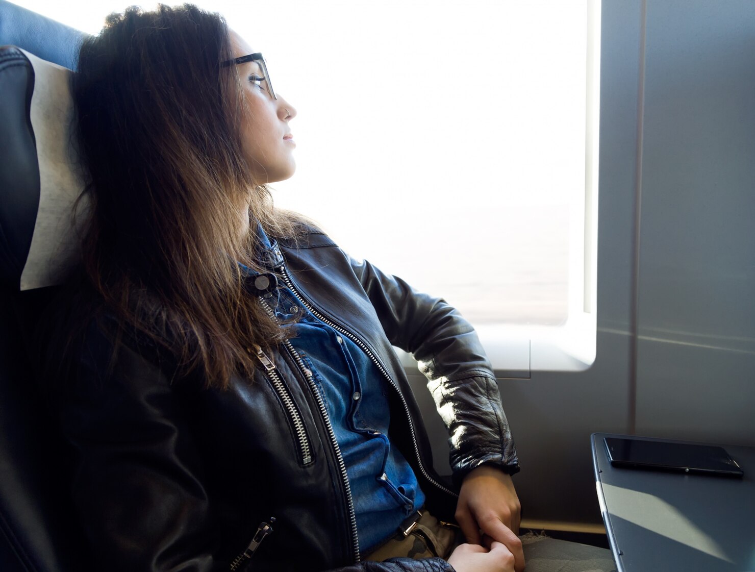 Une femme pensive dans un avion | Source : Freepik