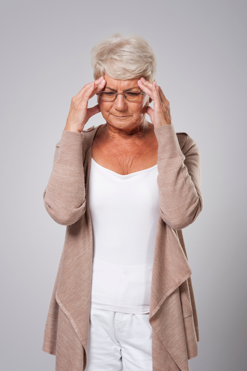 Une femme âgée stressée se tenant la tête | Source : Freepik