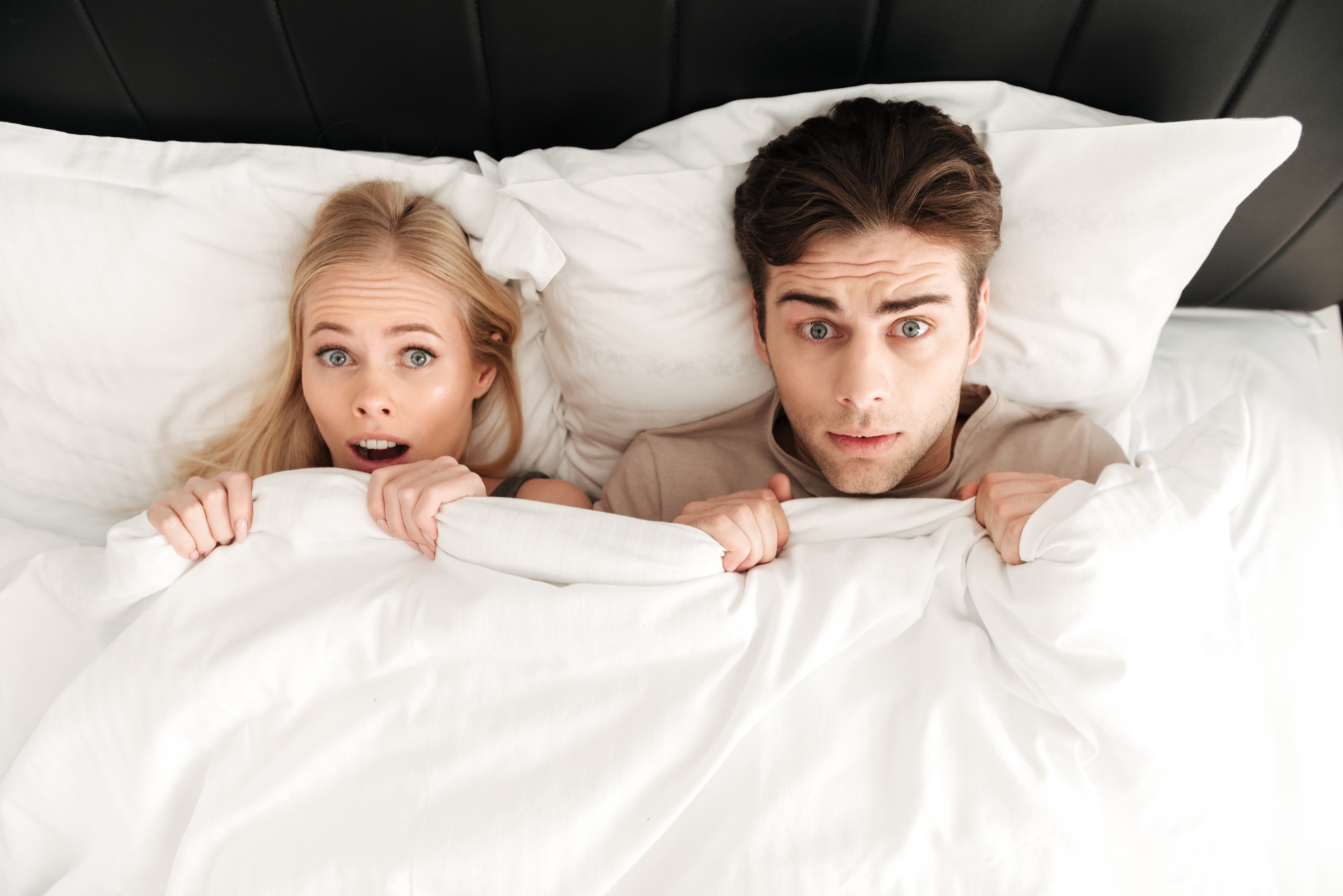 Un couple surpris au lit ensemble | Source : Freepik