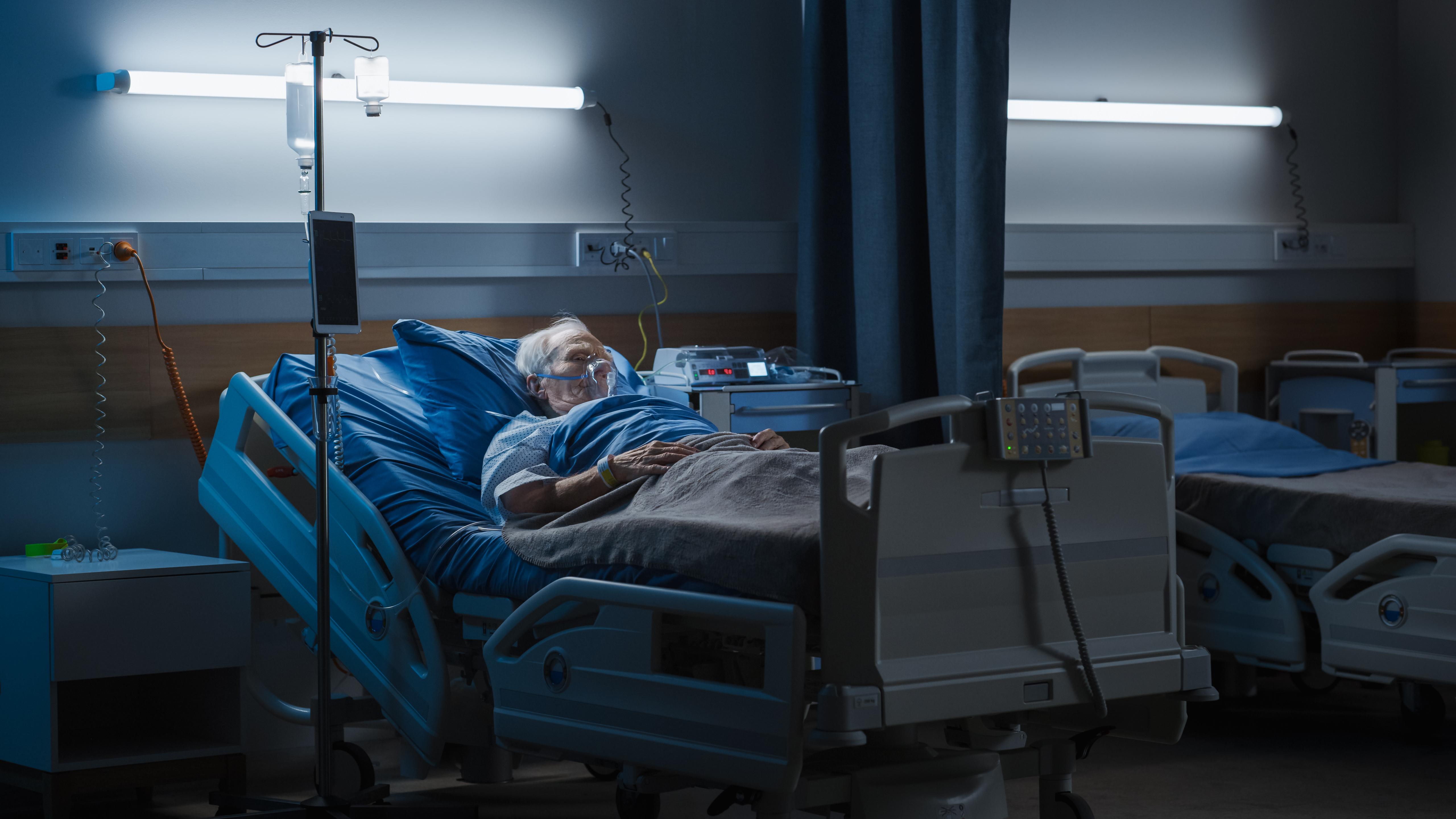 Un homme âgé portant un masque à oxygène endormi dans son lit d'hôpital | Source : Shutterstock