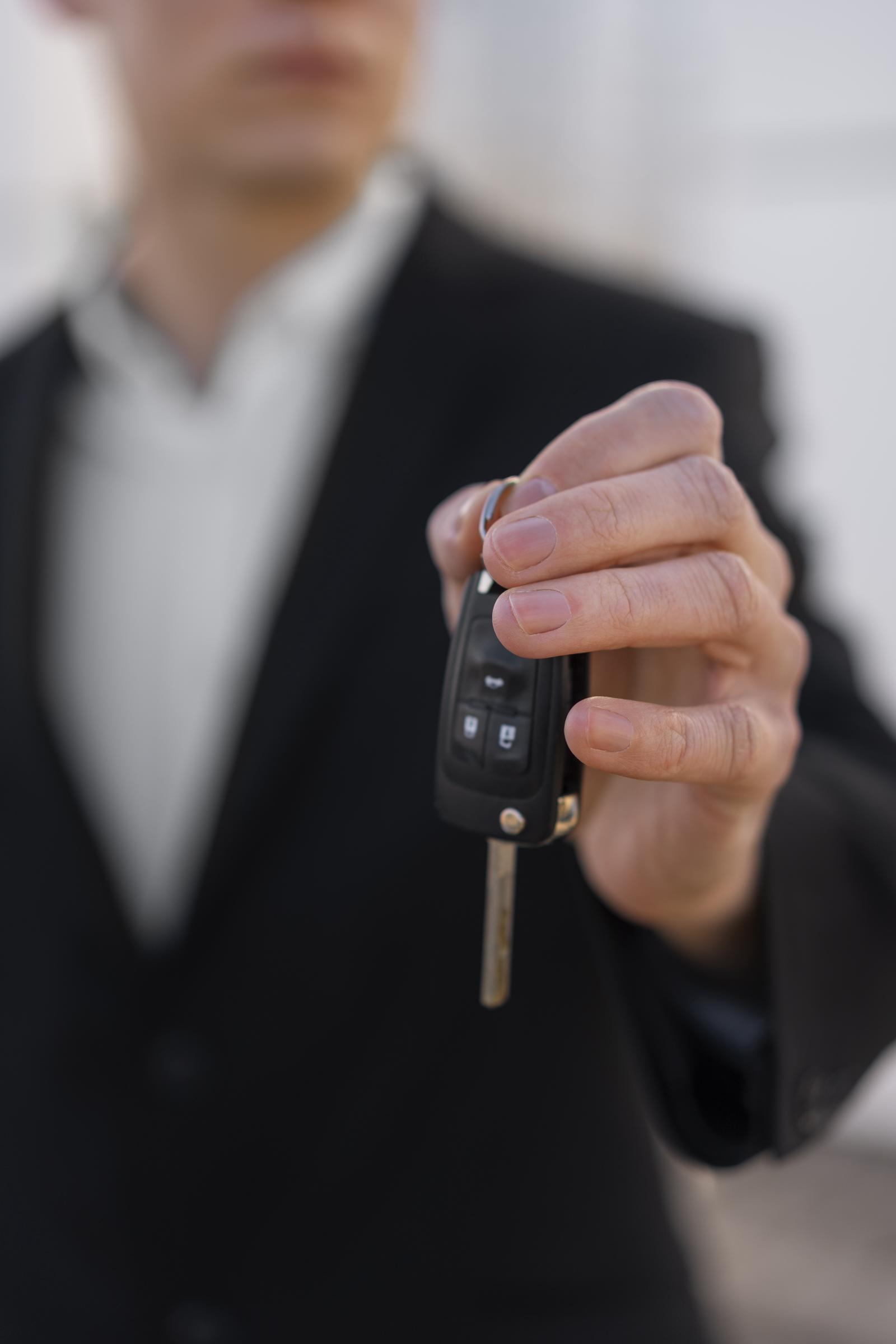 Un homme tenant une clé de voiture | Source : Freepik