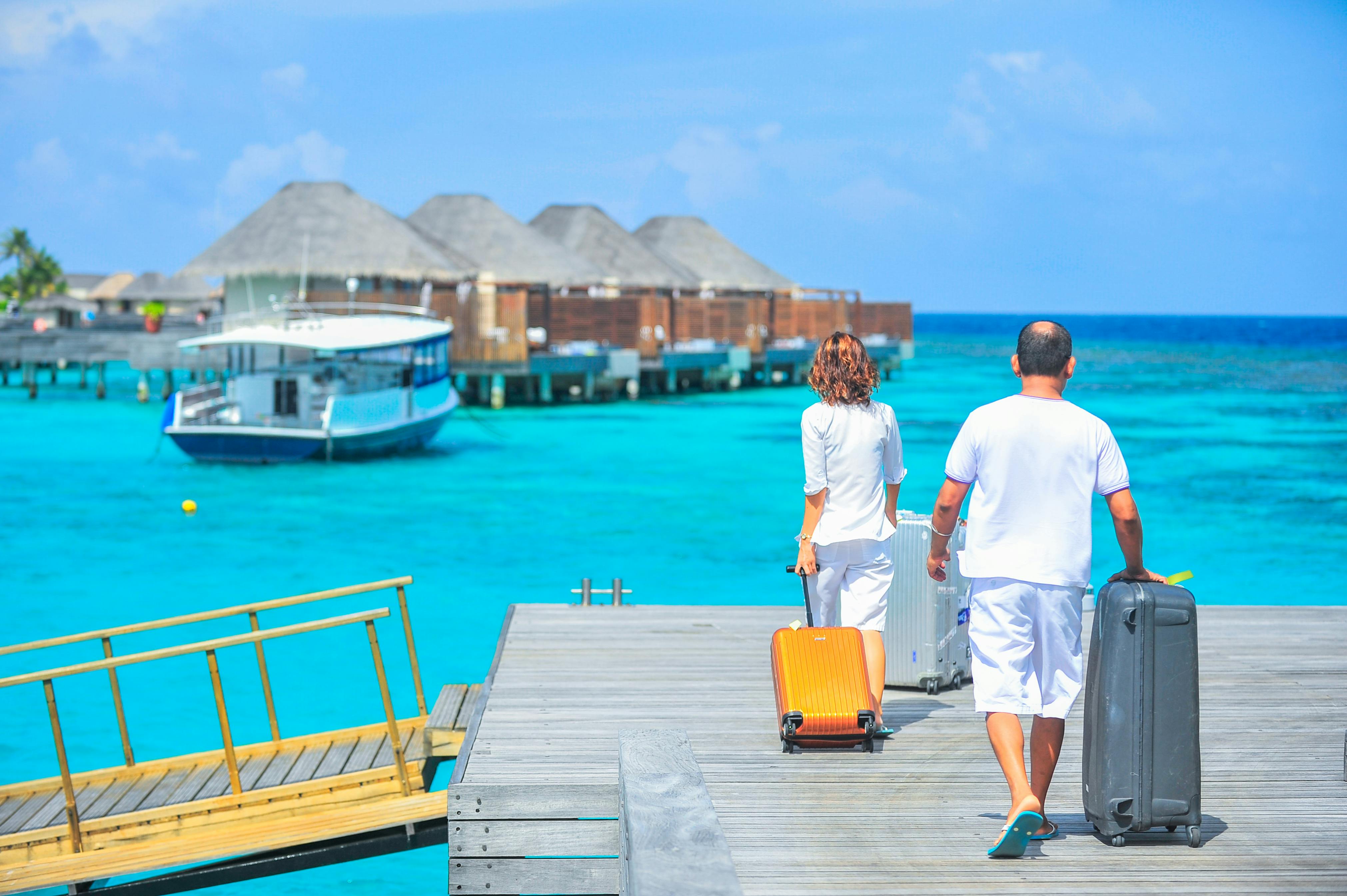 Un homme et une femme marchant sur le quai avec des valises | Source : Pexels