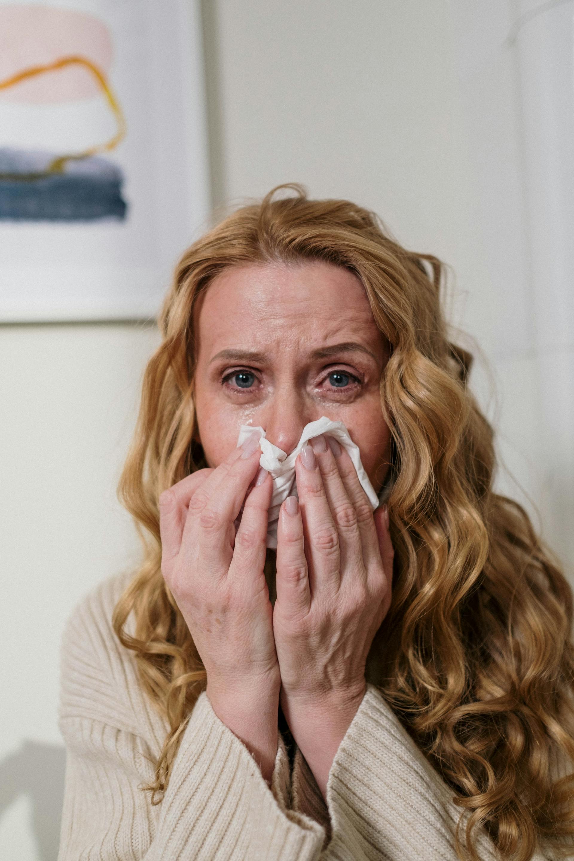 Une femme s'essuie le nez avec un mouchoir en pleurant | Source : Pexels