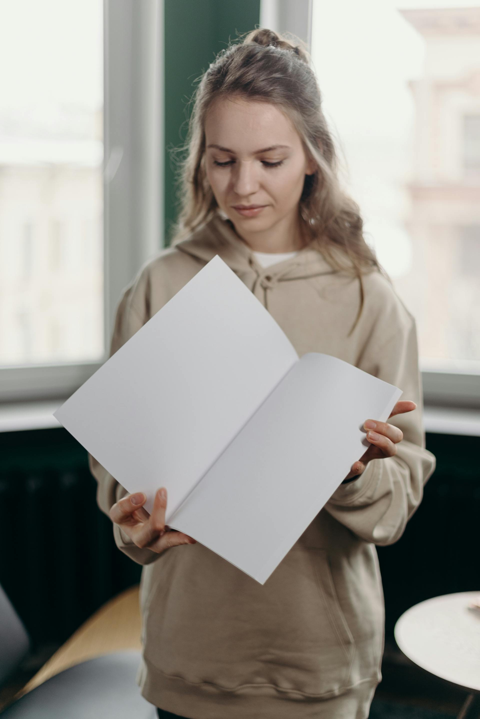 Une femme regardant un papier blanc dans ses mains | Source : Pexels