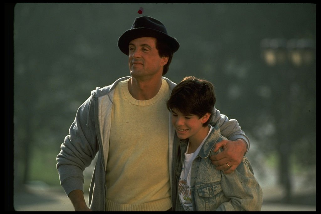 L'acteur Sylvester Stallone avec son bras autour de son fils, Sage, dans une scène du film Rocky V de 1990 | Photo : Getty Images