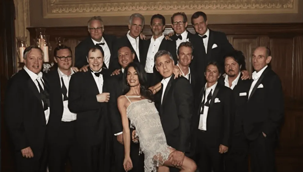 George Clooney et son épouse Amal Clooney posant pour une photo avec les 14 amis de l'acteur | Source : Youtube.com/AccessHollywood
