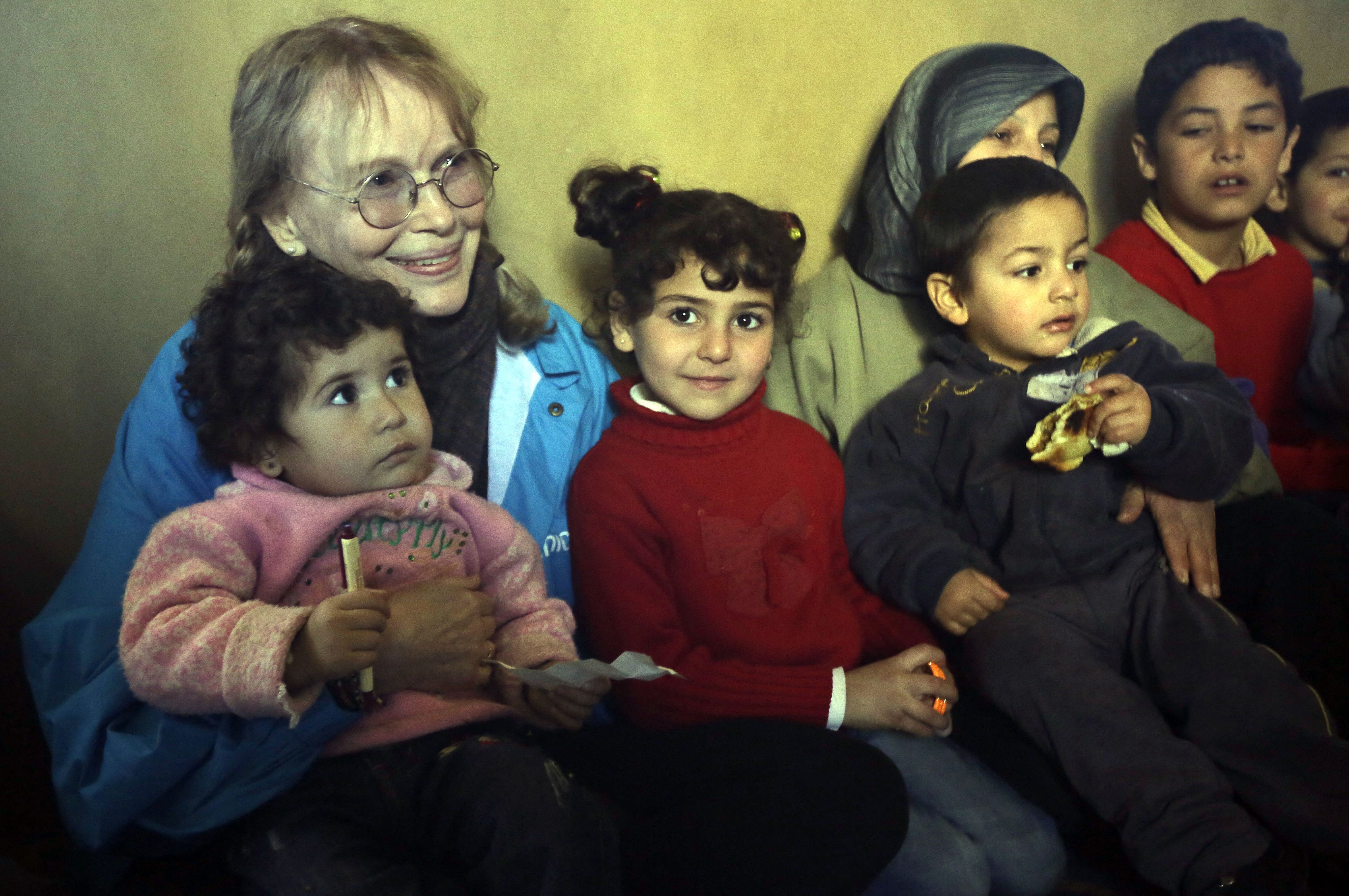 L'actrice américaine Mia Farrow (G), ambassadrice itinérante de l'UNICEF, rend visite à des réfugiés syriens à Baalbek, dans la vallée libanaise de la Bekaa, le 15 janvier 2013. | Source : Getty Images