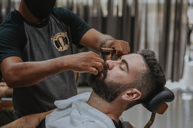 Un homme qui se fait coiffer dans un salon de coiffure | Photo : Getty Images
