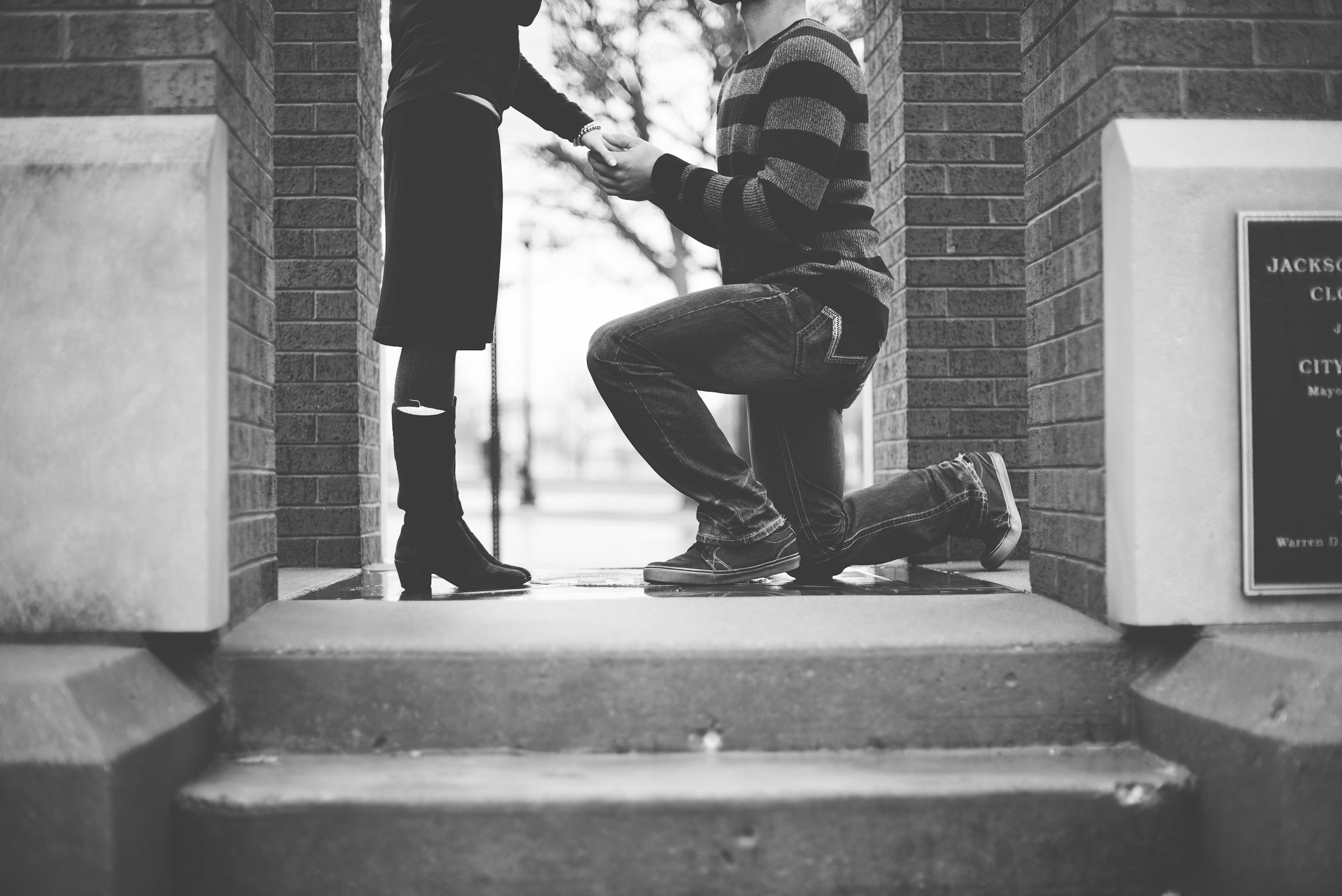 Plan en niveaux de gris d'un homme demandant une femme en mariage | Source : Unsplash