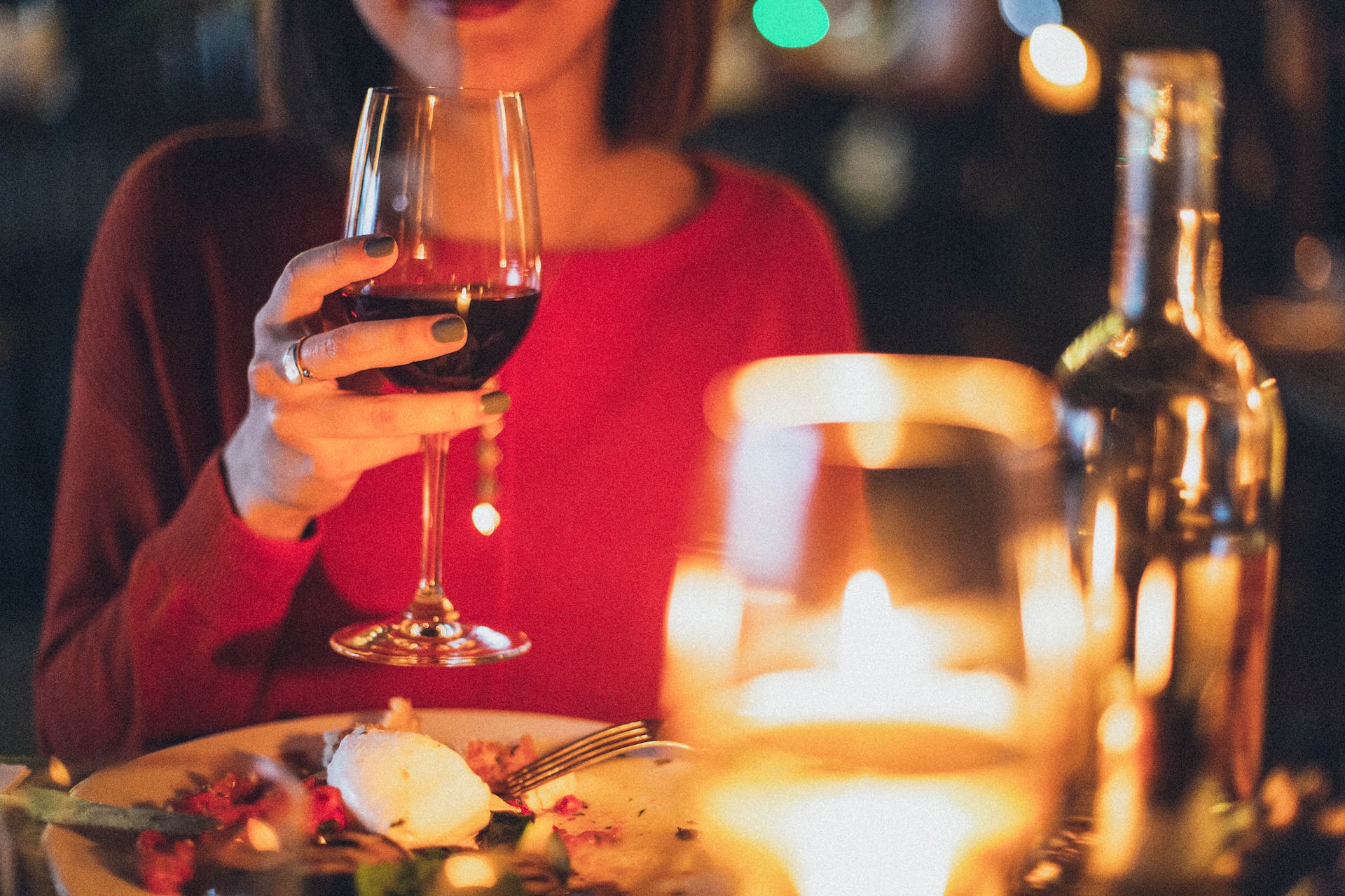 Une femme tenant un verre de vin pendant le dîner dans un restaurant | Source : Pexels