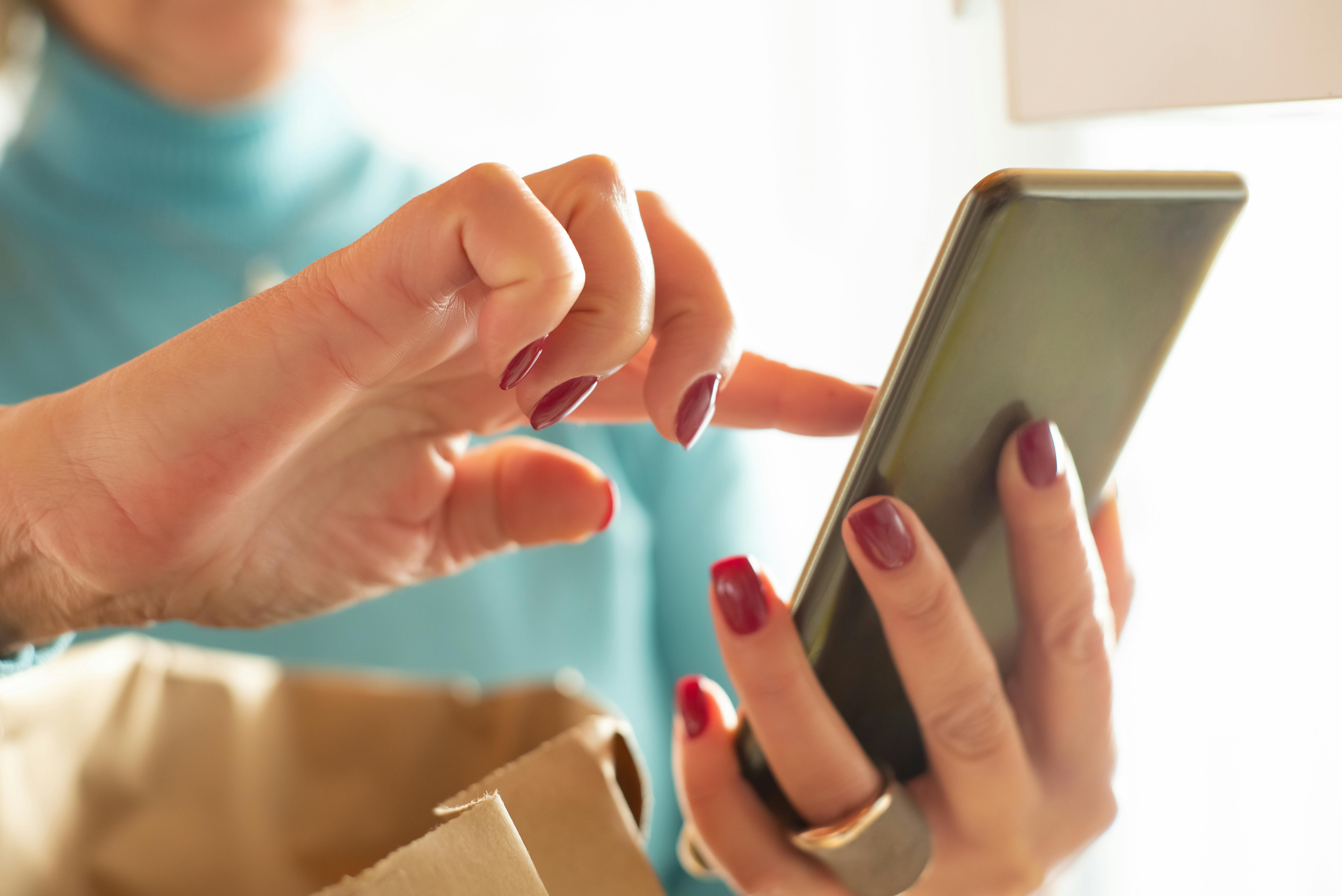 Une femme tenant un téléphone dans ses mains | Source : Pexels