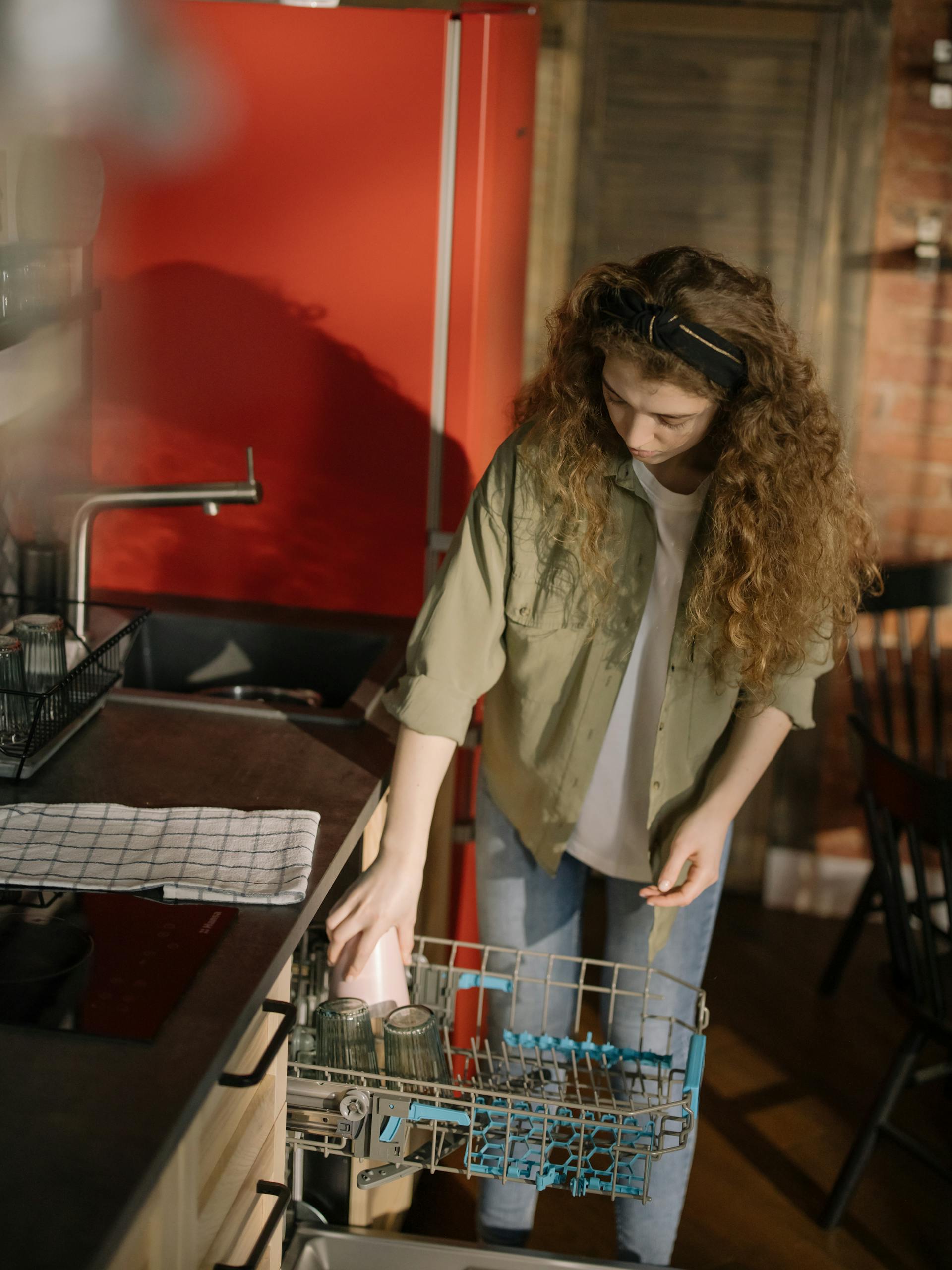 Une jeune femme utilisant un lave-vaisselle | Source : Pexels