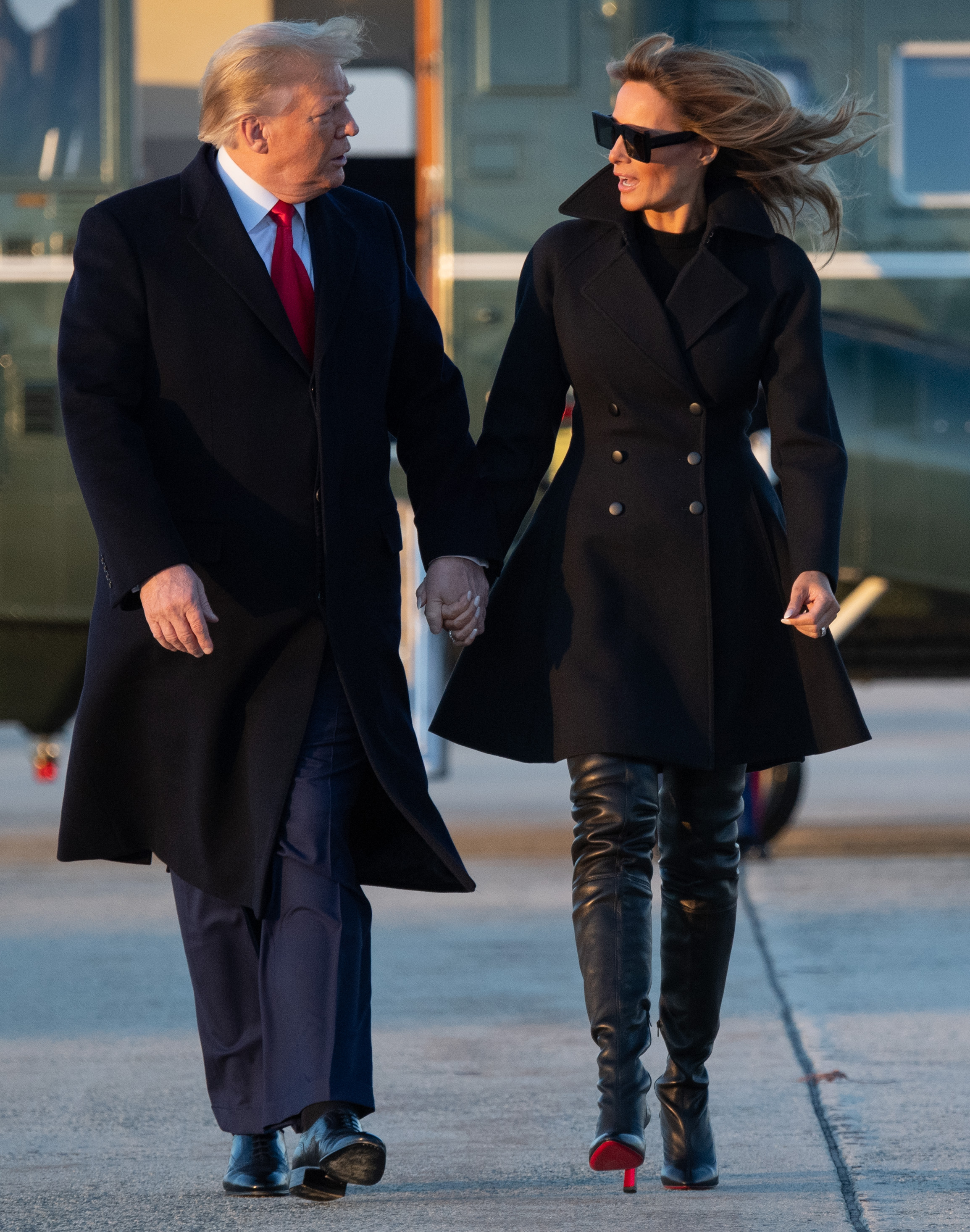 La Première Dame Melania Trump quitte la base militaire d'Andrews, dans le Maryland, le 23 décembre 2020, pour passer Noël et le Nouvel An à Mar-a-Lago, vêtue d'un manteau noir à double boutonnage, assorti à des bottes en cuir noir Christian Louboutin montant jusqu'aux cuisses, dotées de talons aiguilles vertigineux et de semelles rouges emblématiques.