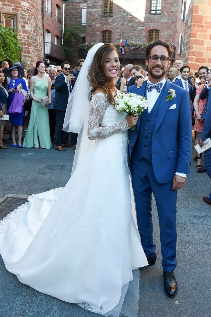 L'avocat français Thomas Hollande et la journaliste française Émilie Broussouloux célèbrent et posent pour des photos après s'être mariés à l'église de Meyssac, le 8 septembre 2018.  | Photo : Getty Images