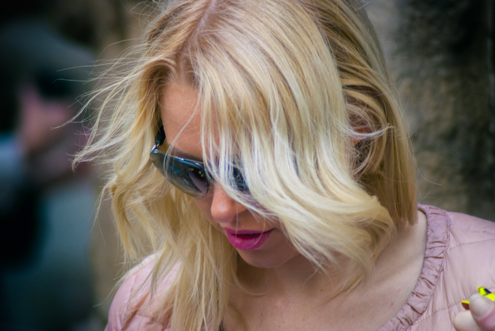 Une femme aux cheveux blonds qui regarde vers le bas en portant des lunettes de soleil | Source : Flickr
