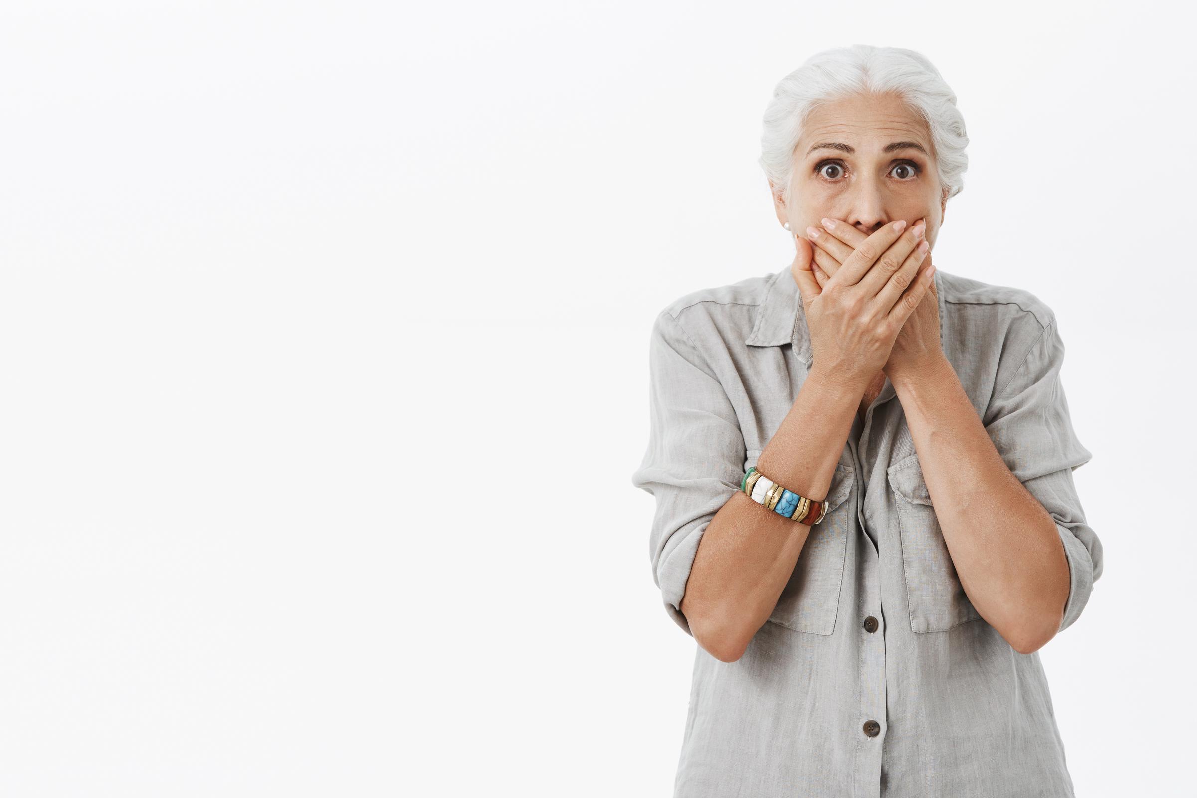 Une femme âgée effrayée se couvrant la bouche | Source : Freepik