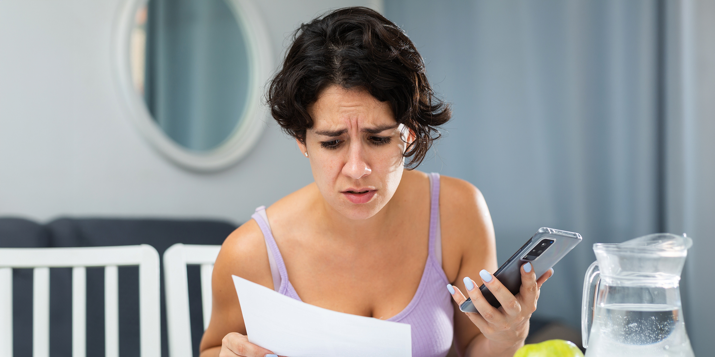 Une femme fronçant les sourcils étudie une feuille de papier | Source : Shutterstock