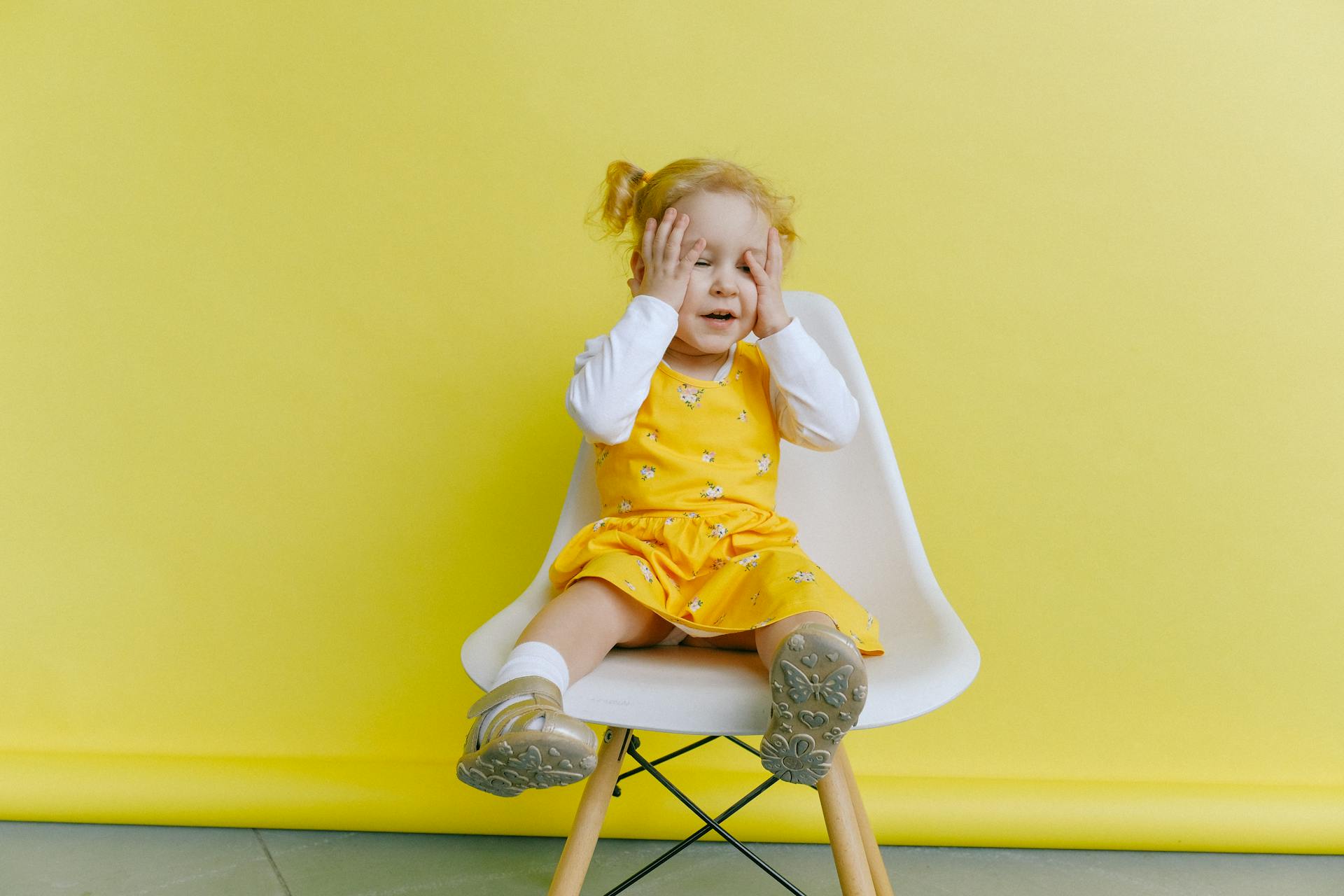 Une petite fille assise sur une chaise | Source : Pexels