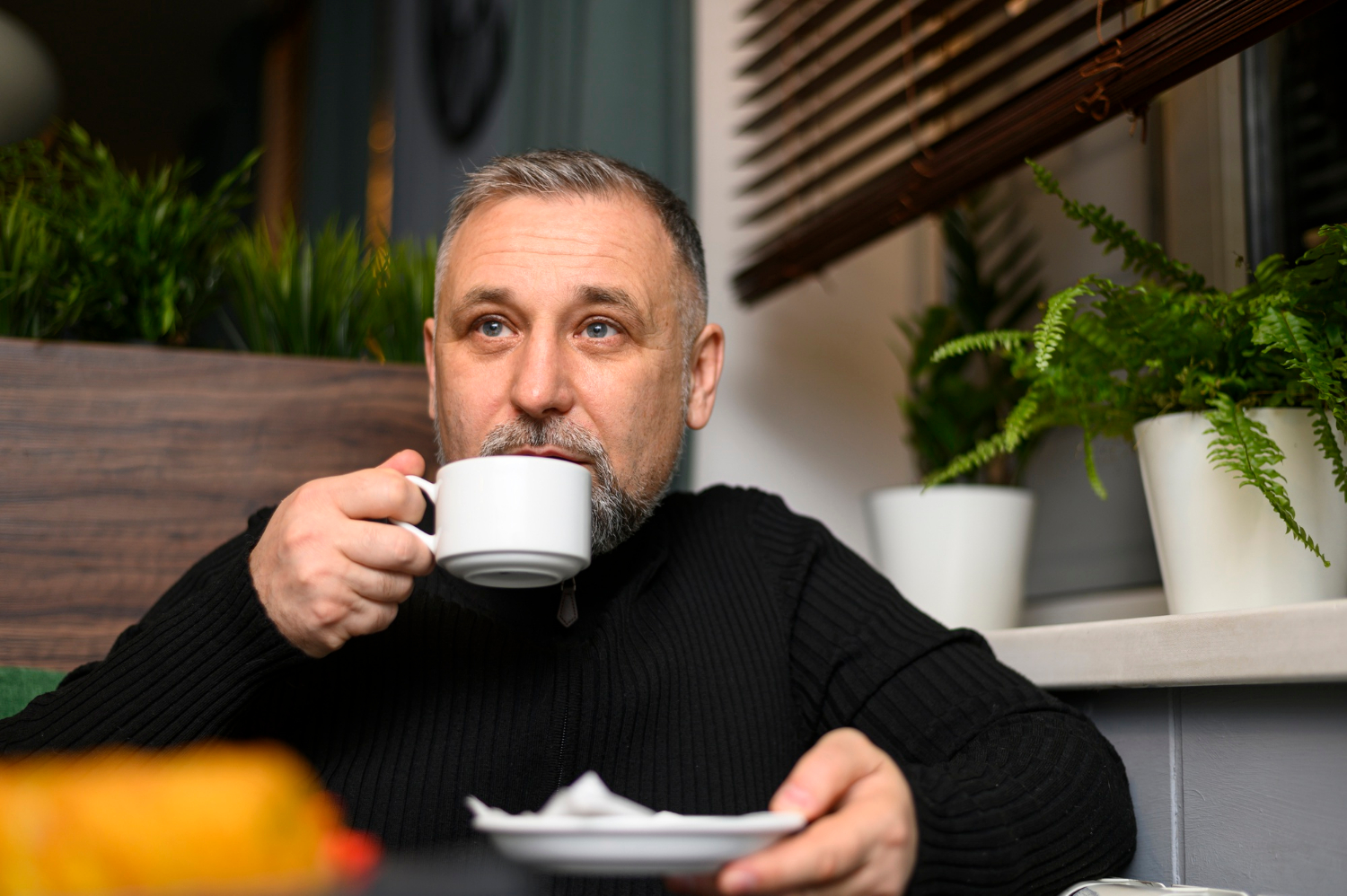 Un homme anxieux tenant une tasse en céramique | Source : Freepik
