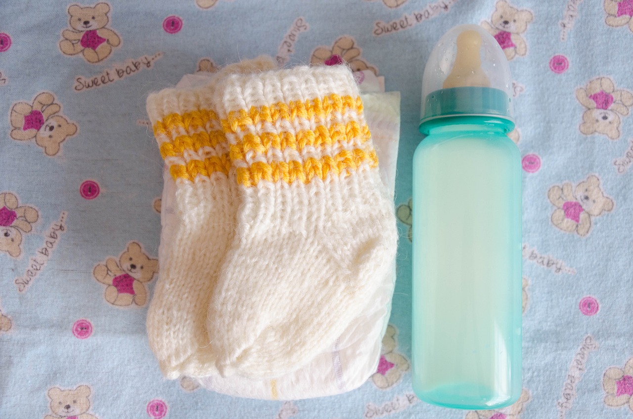 Des chaussons de bébé et un biberon | Source : Pixabay