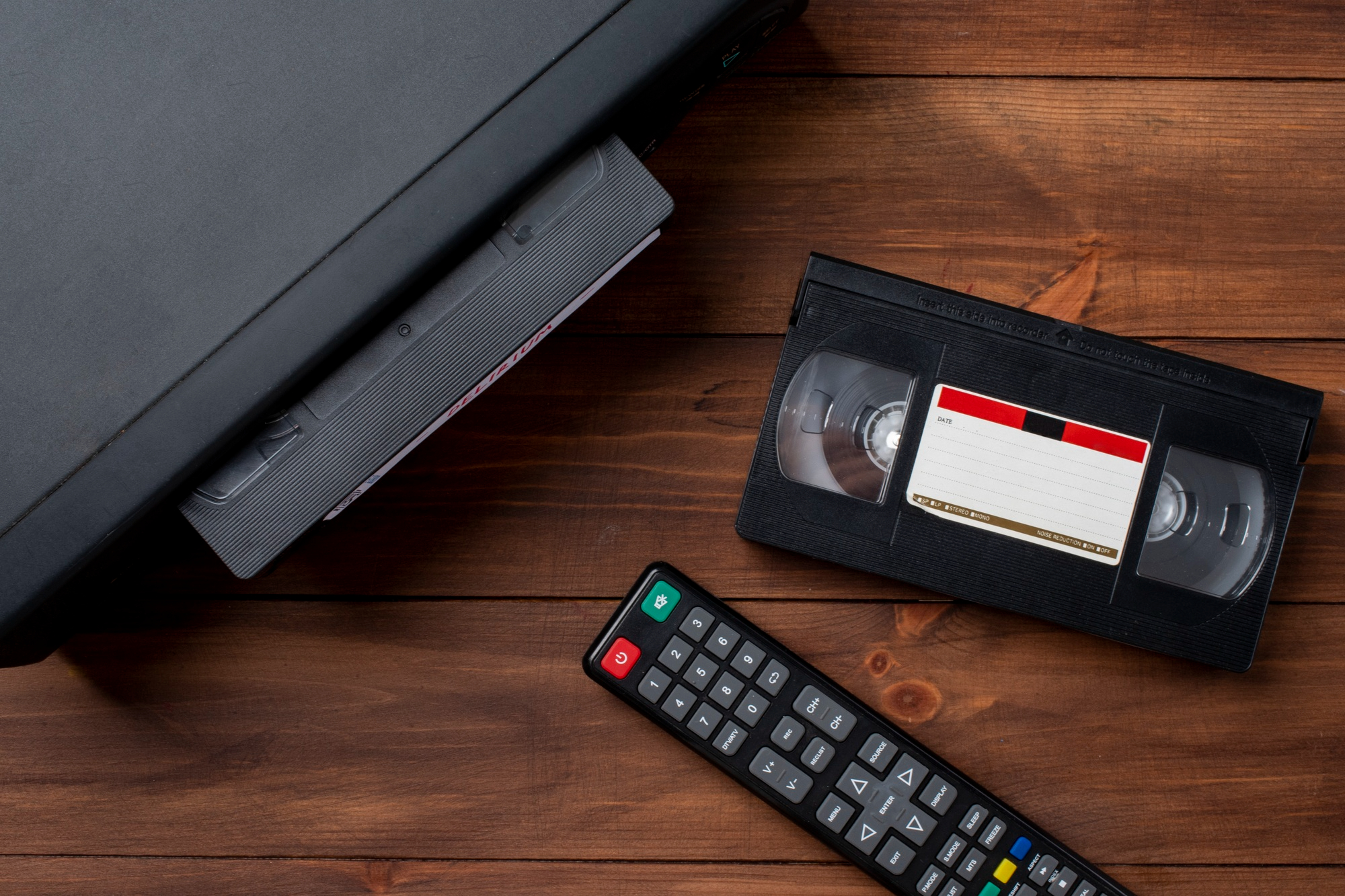 Un lecteur VHS avec une cassette et une télécommande | Source : Freepik