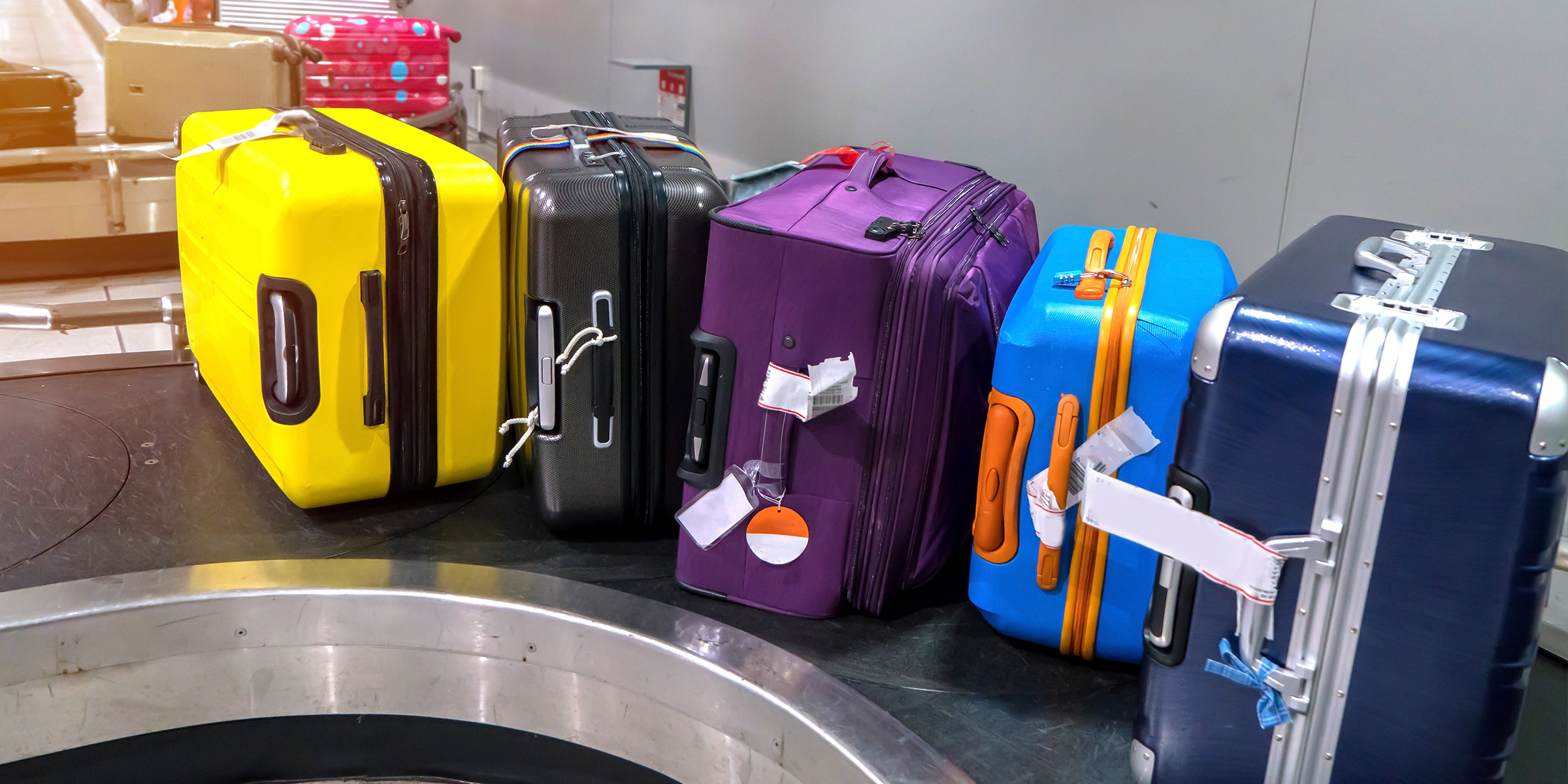 Plusieurs sacs de voyage sur un tapis roulant | Source : Shutterstock