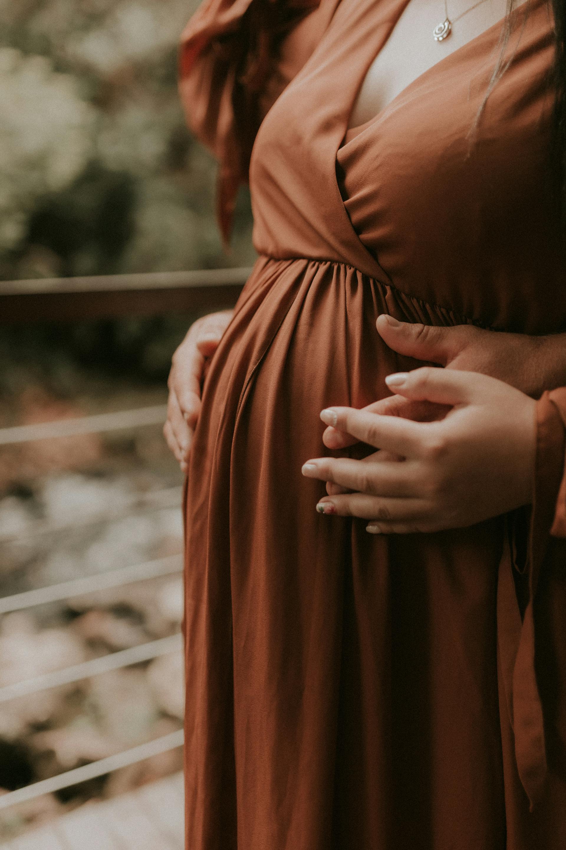 Un couple se tenant par la main tout en touchant le baby bump de la femme enceinte | Source : Pexels