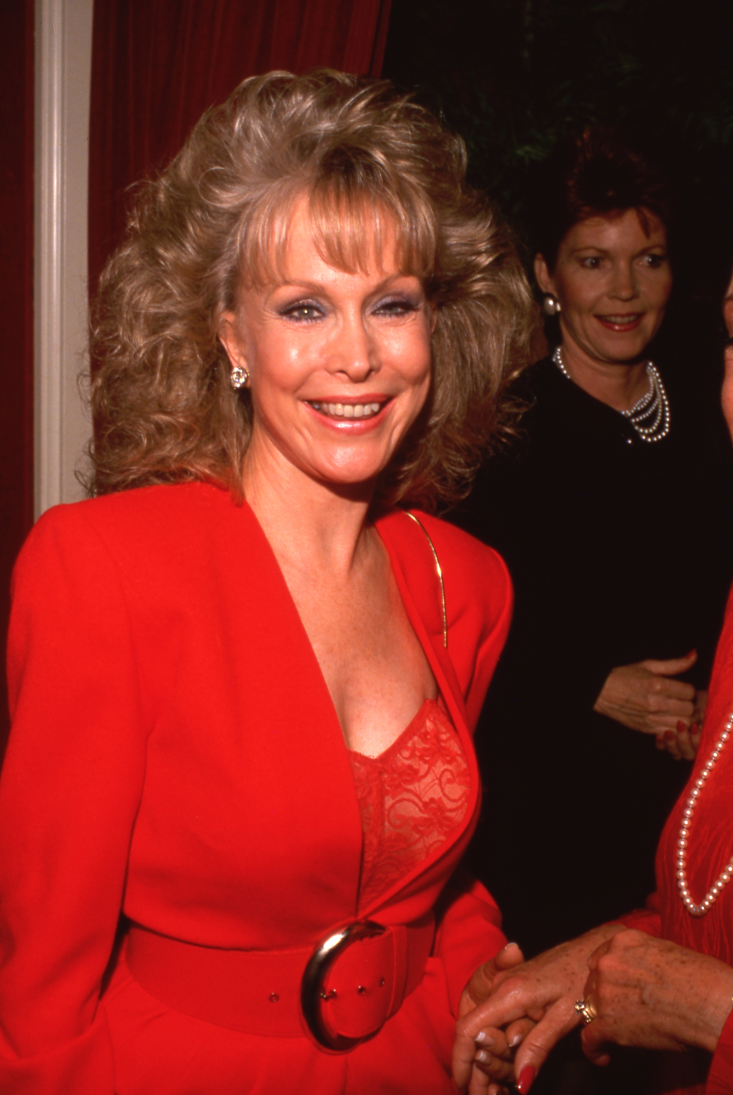 Barbara Eden porte un tailleur rouge avec un haut en dentelle alors qu'elle assiste à une fête en 1980. | Source : Getty Images