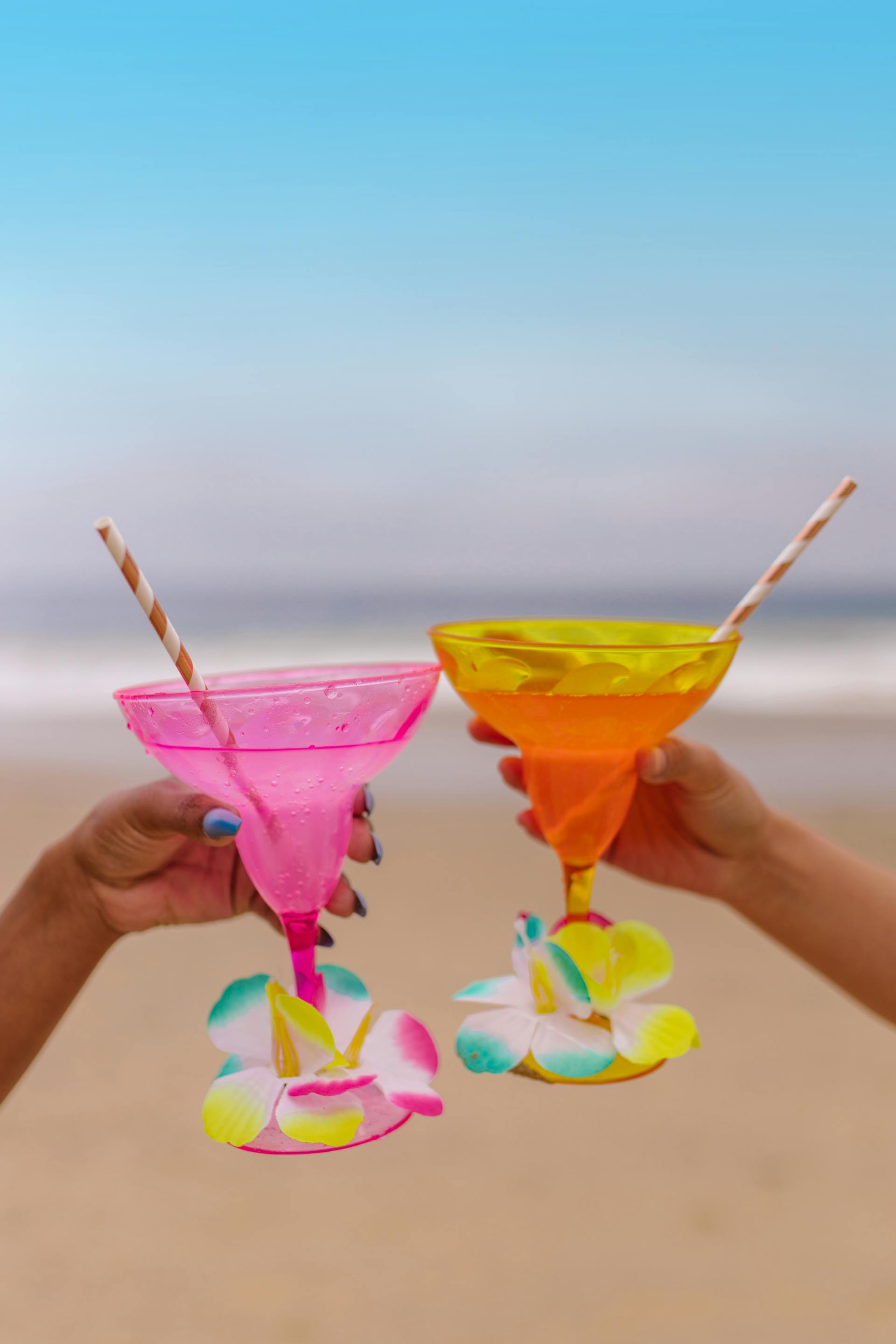 Des personnes tenant des cocktails à la plage | Source : Pexels