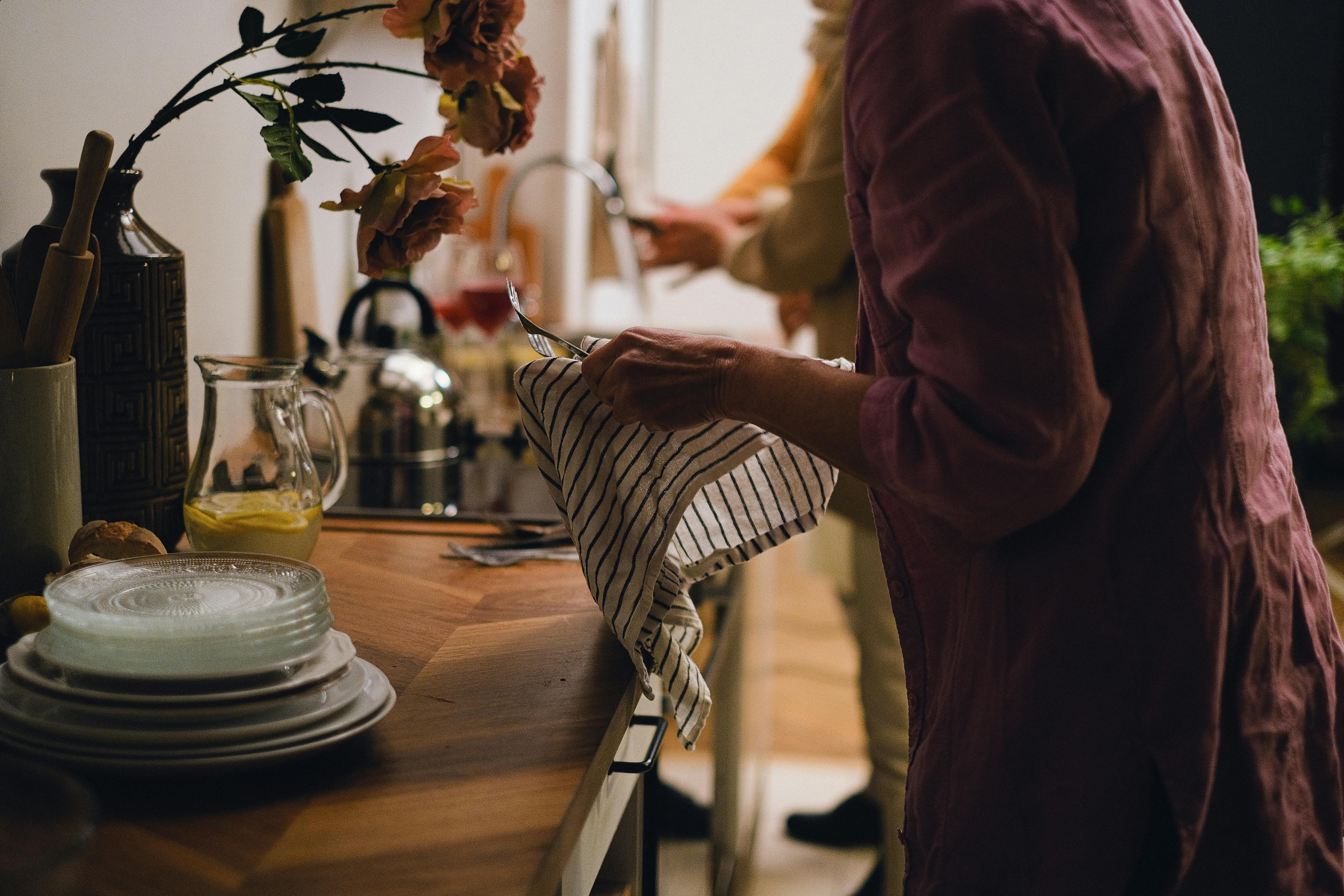 Une femme qui sèche la vaisselle à l'évier | Source : Pexels