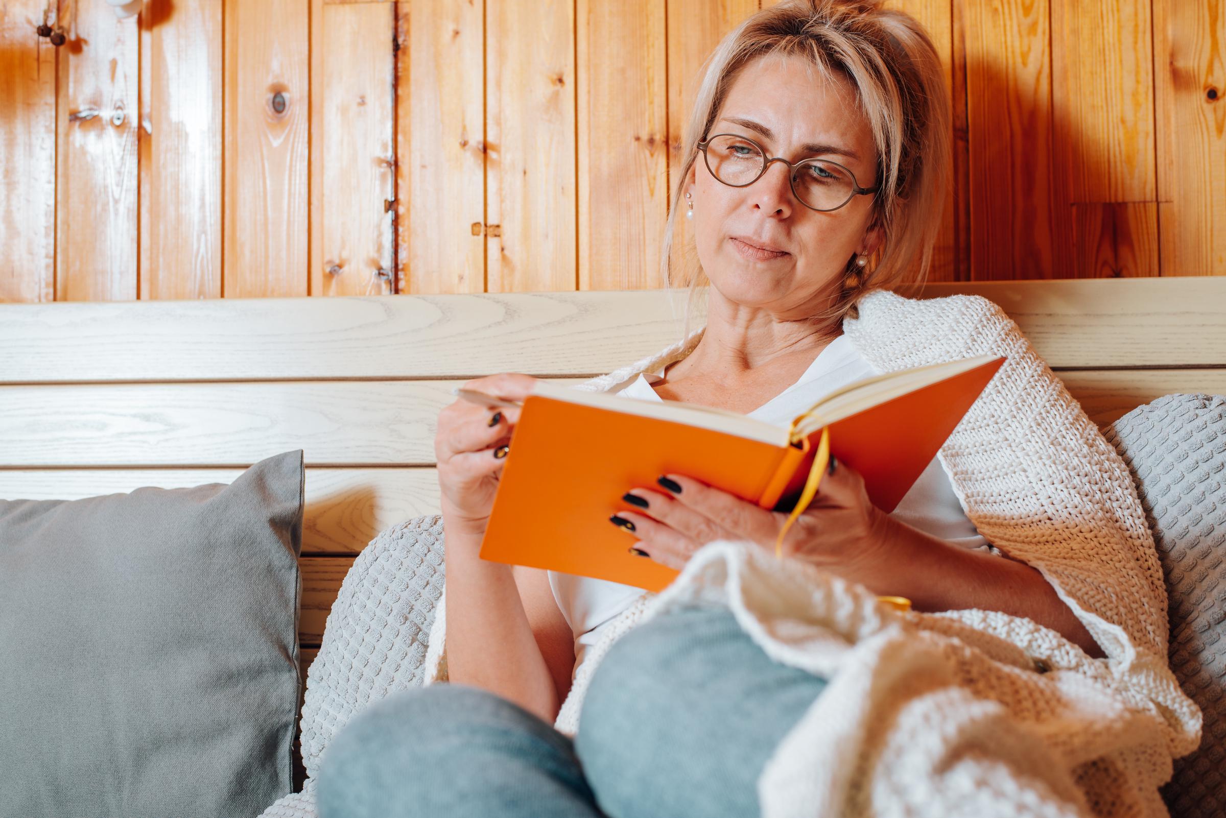 Une femme qui tient un journal dans sa chambre | Source : Getty Images