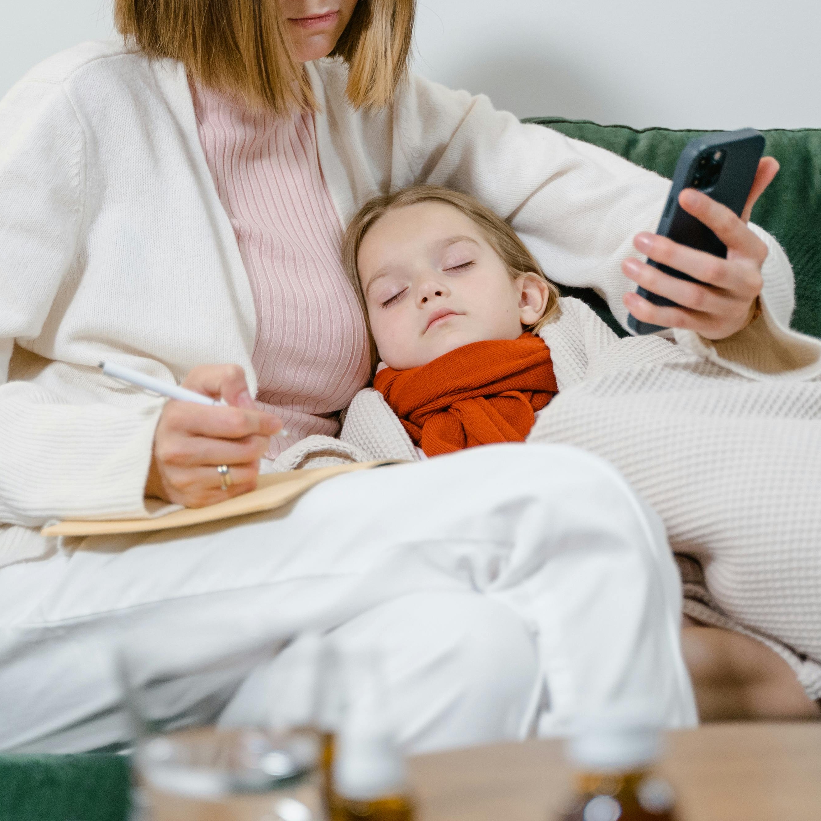 Une femme s'occupe d'un enfant malade tout en prenant des notes | Source : Pexels