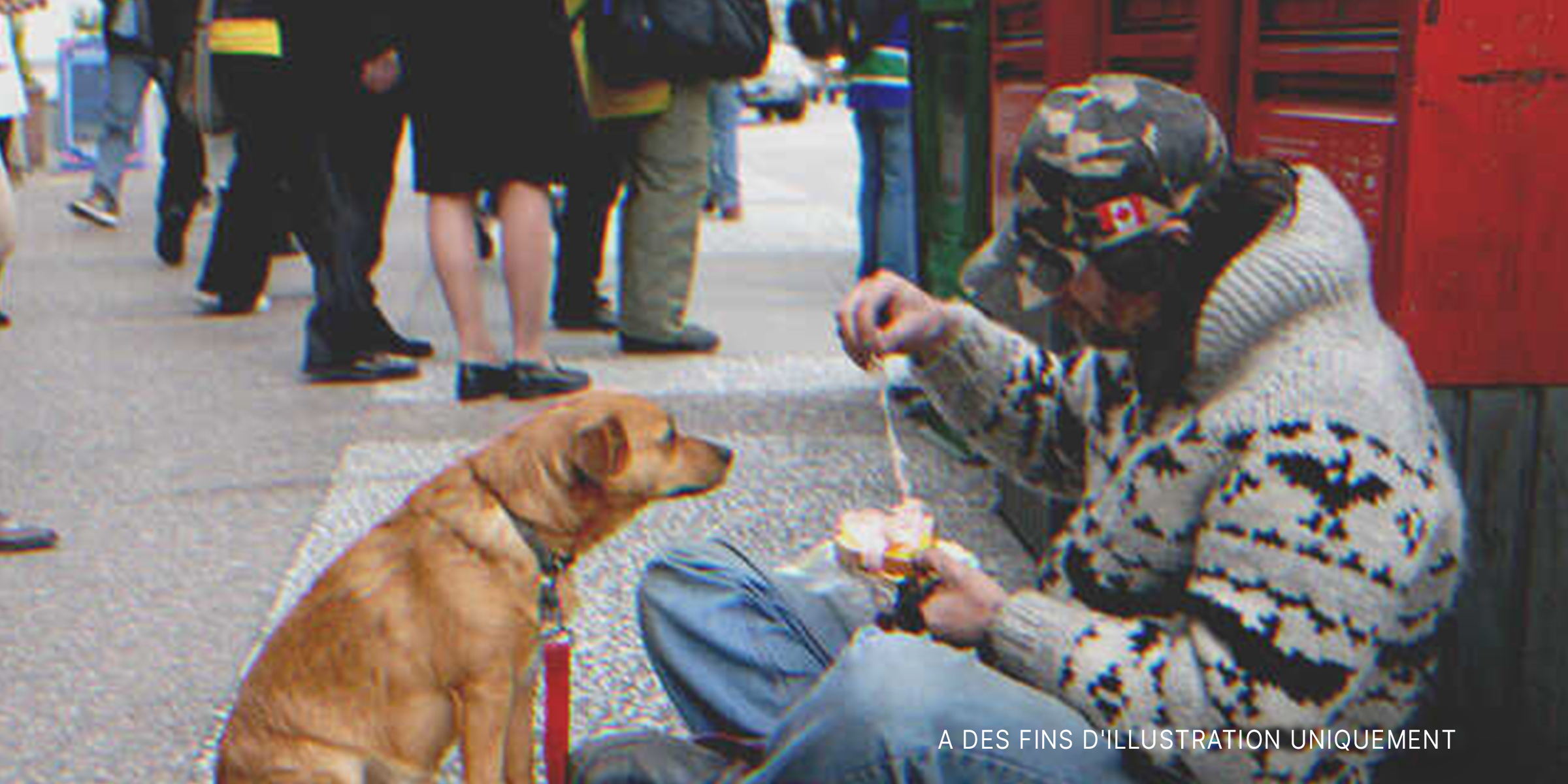 Un homme sans abri nourrissant un chien dans la rue | Source : Shutterstock