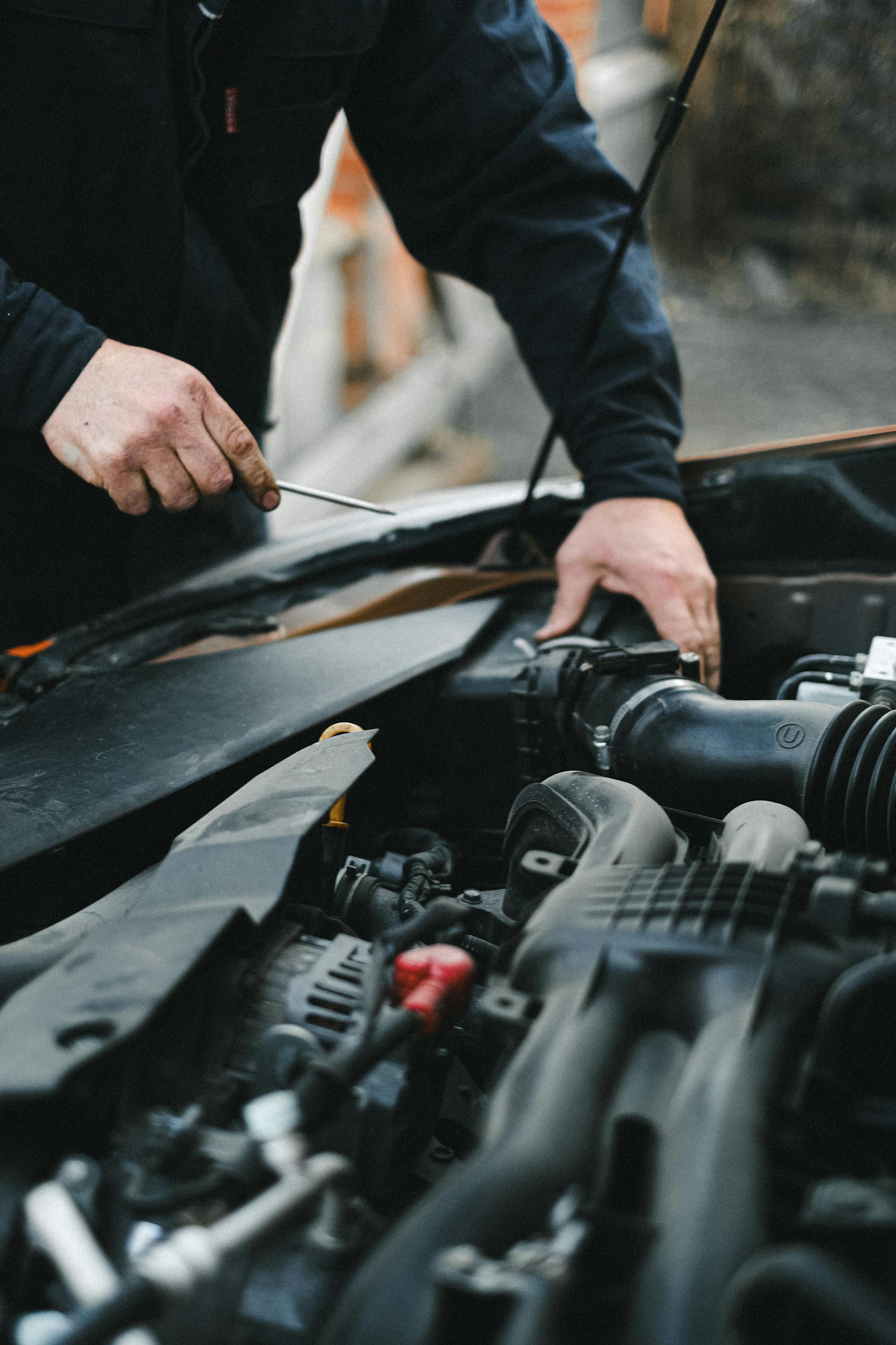 Un homme travaillant sur le moteur d'une voiture | Source : Pexels