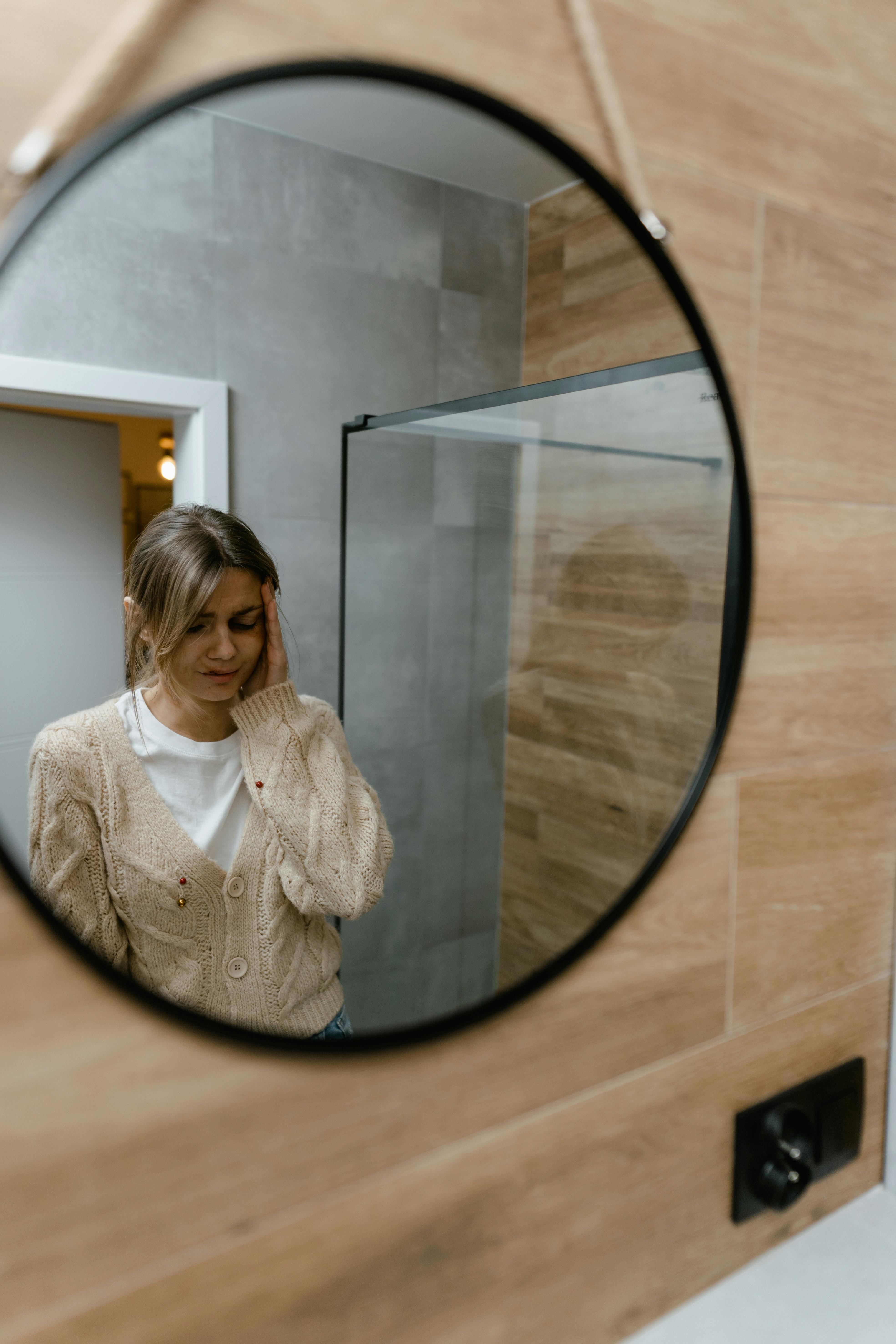 Une femme inquiète qui se regarde dans le miroir | Source : Pexels