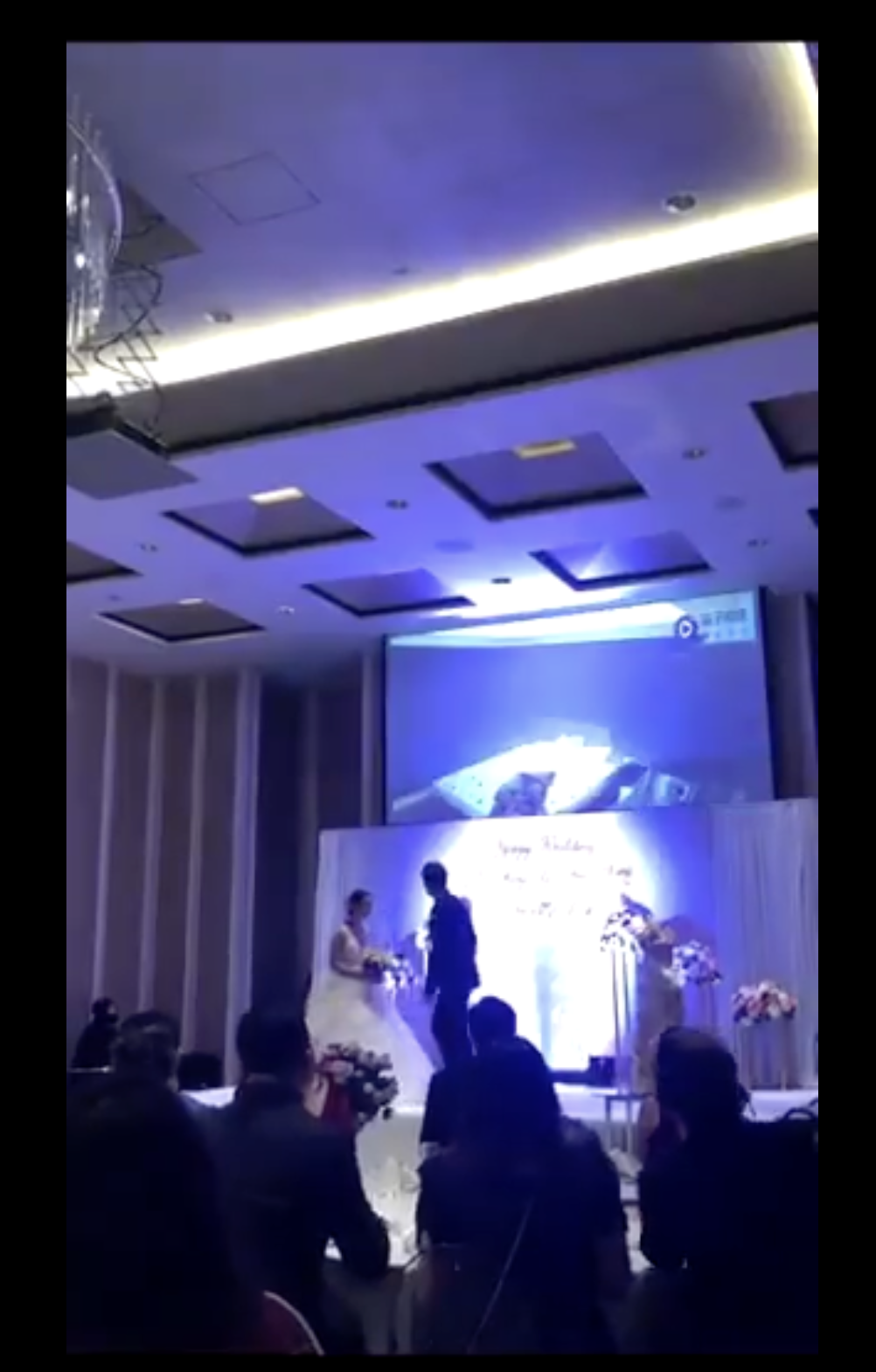 Les mariés se tournent vers le projecteur situé derrière eux | Source : twitter.com/TuanConCom1
