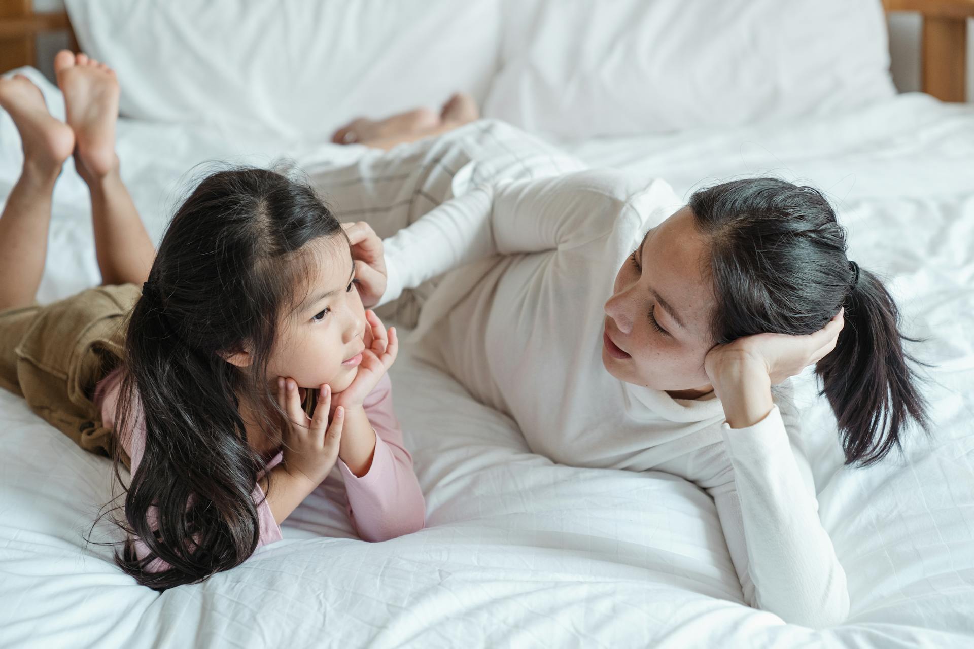 Une femme qui parle à sa fille sur le lit | Source : Pexels