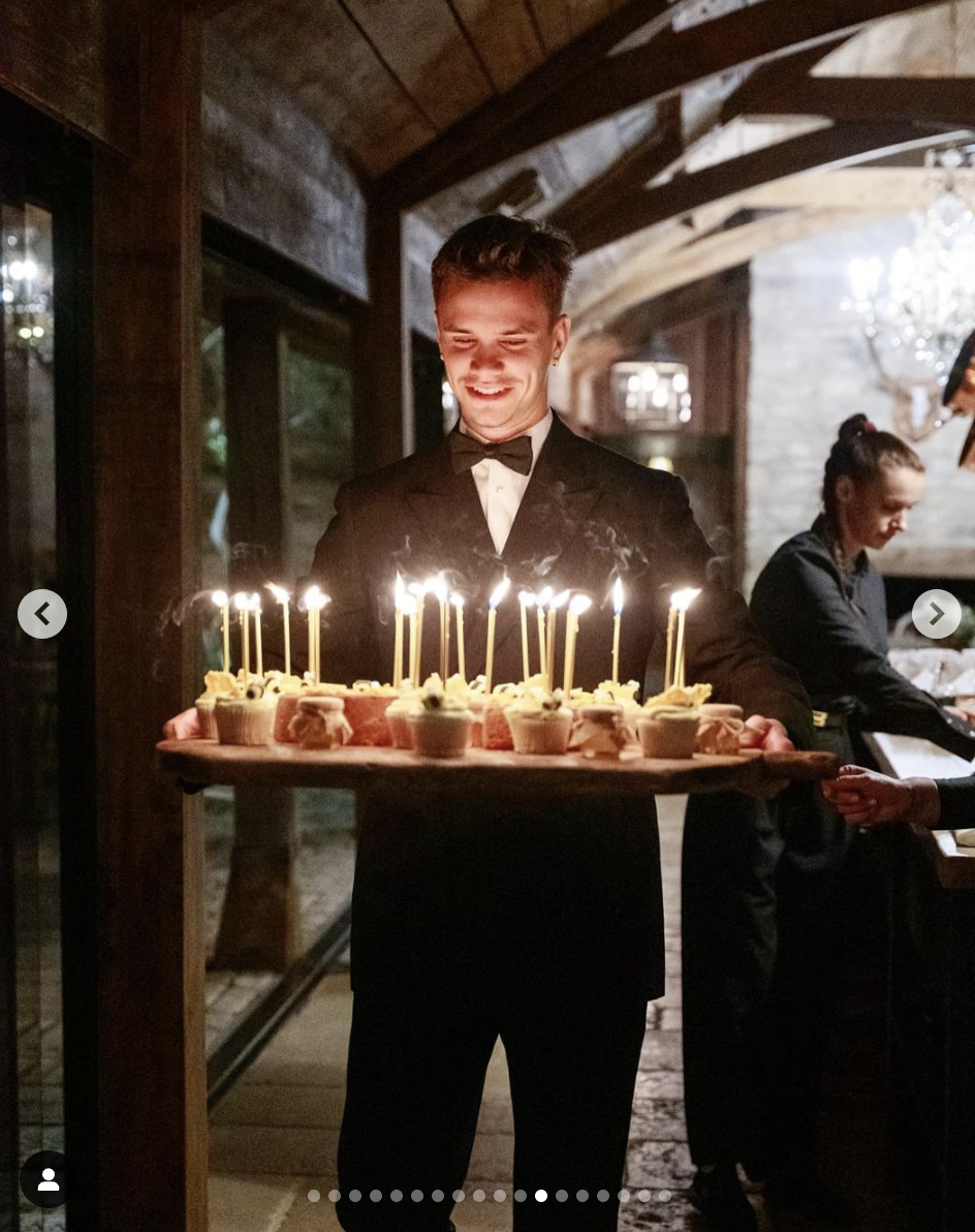 Romeo Beckham tenant un plateau de cupcakes lors de la fête pour les 50 ans de son père, comme on peut le voir sur une photo datée du 4 mai 2025 | Source : Instagram/victoriabeckham