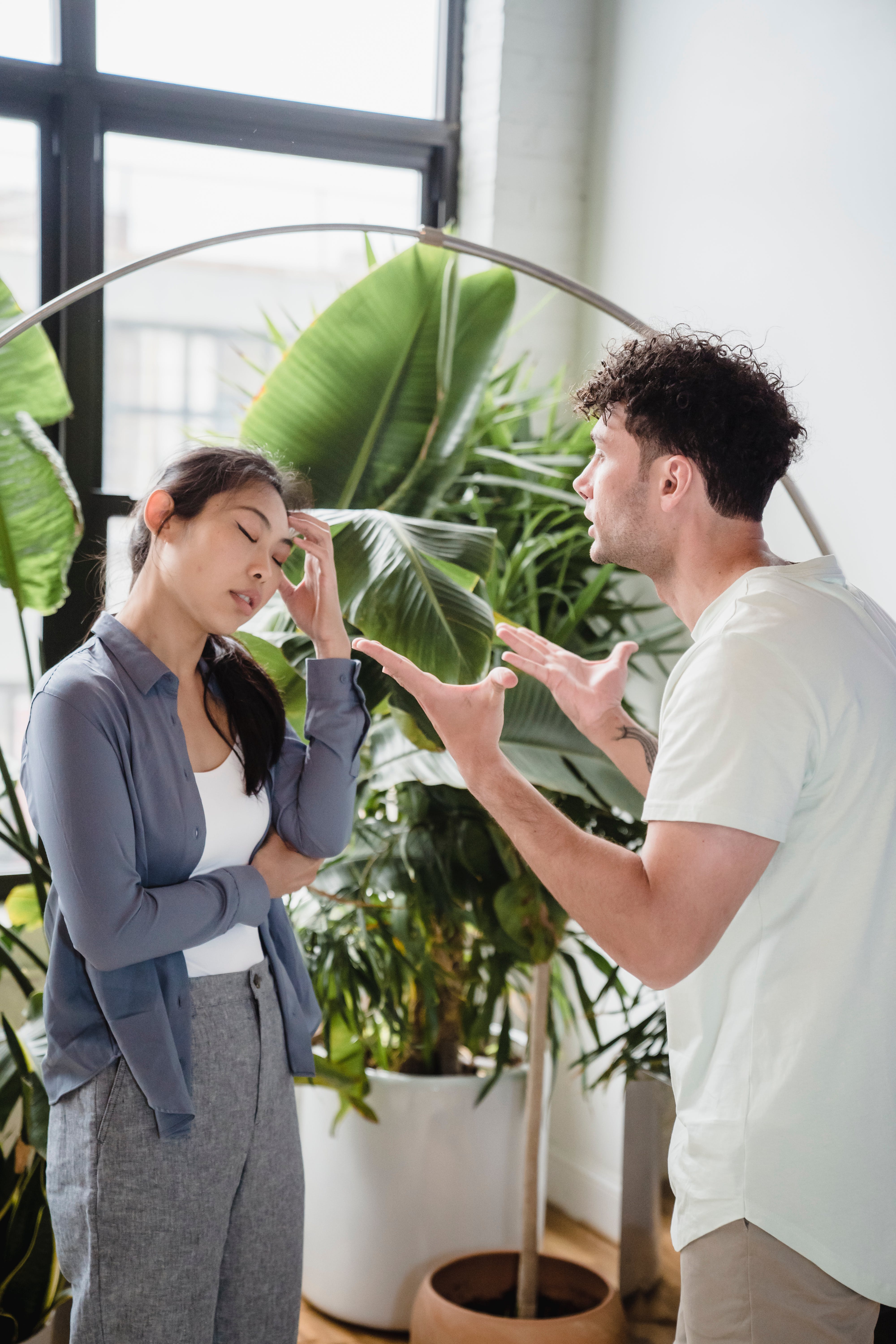 Un homme fait des gestes avec ses deux mains tandis qu'une femme a les yeux fermés et la main sur la tempe lors d'une conversation | Source : Pexels