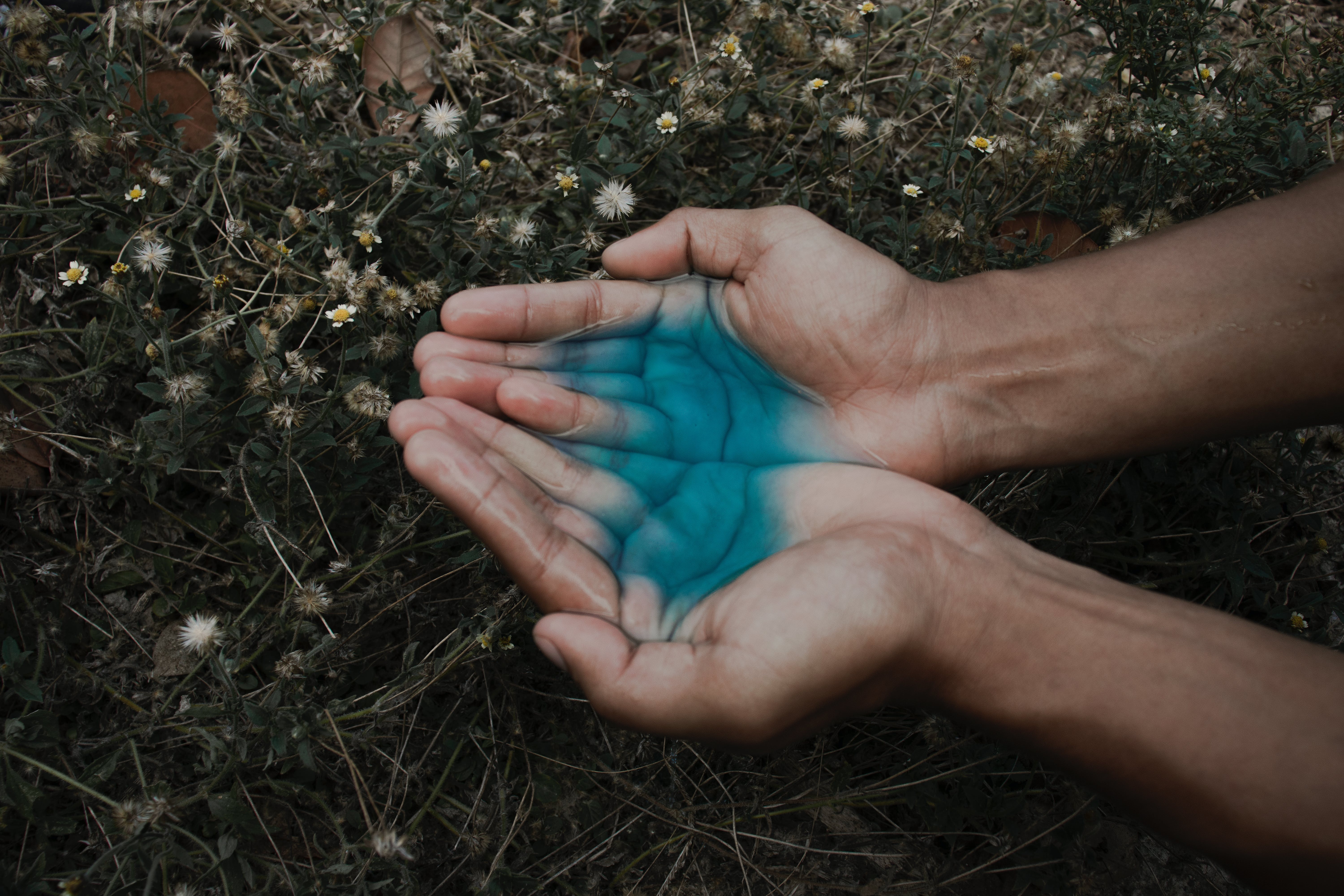 Una persona con un líquido azul en las manos. | Fuente: Pexels