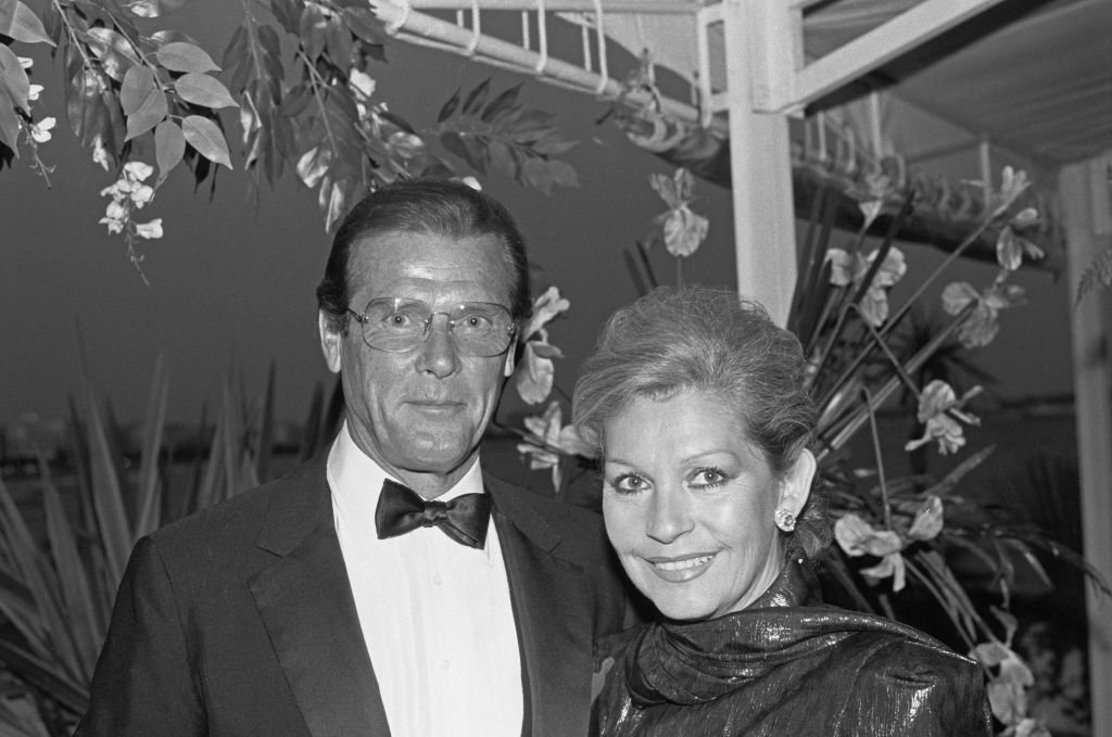 L'acteur anglais Roger Moore avec sa femme Luisa Mattioli au Festival de Cannes, France, vers 1988. | Photo : Getty Images